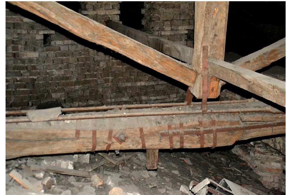 Figure 12: Truss C 6.13: collapsed hooked scarf joint, the forcing key is about to fall down; to integrate the resistance of the tie-beam, a longitudinal iron bar has been flanked to the beam, and a couple of tie-rods have been added a few centimetres above. 