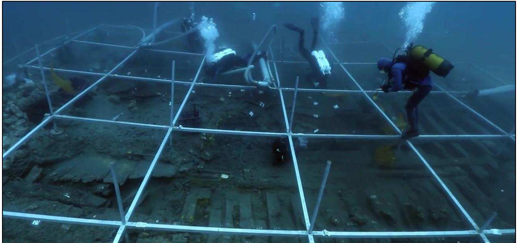 Figure 2-21. A working scene of archaeologists on the Gnalié shipwreck. An archaeologist on the right is recording provenience of an artifact while others are excavating and cleaning the wooden structure. (Photo: Reprinted with permission from Pandozi, 2014)  and cleaning archaeological sites; both tasks require experience and training. 