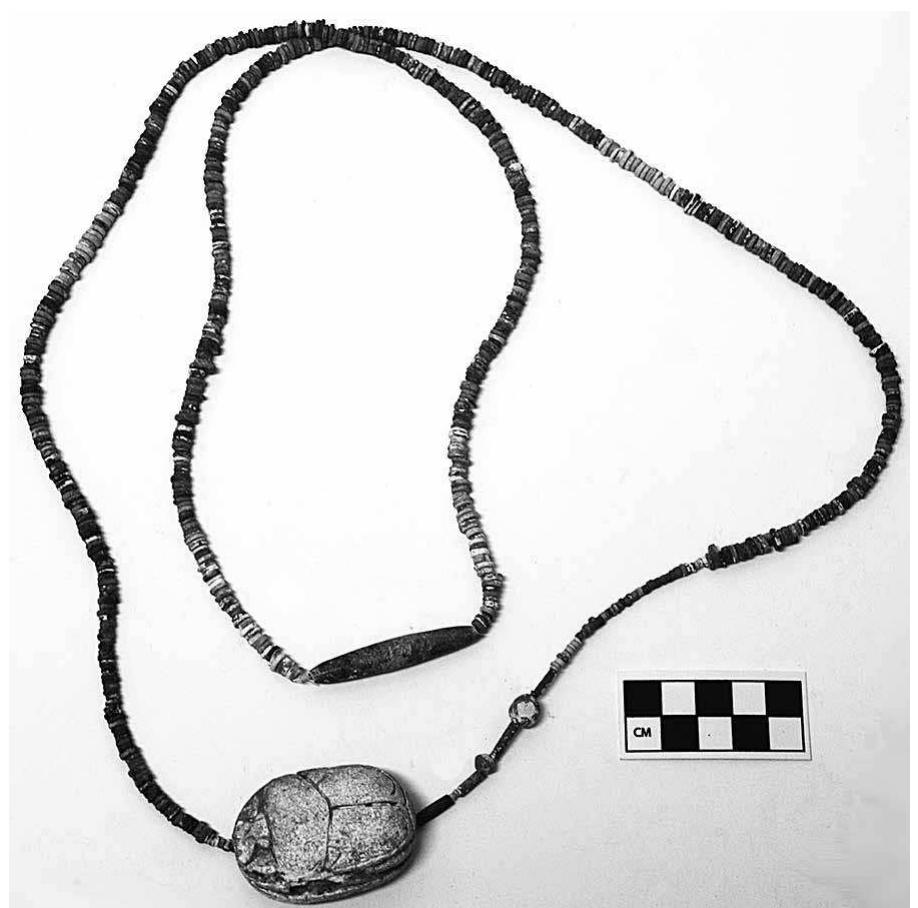 FIG. 24. Necklace reconstructed from more than 500 small beads, large scarab (JCHP 223), and various other beads and elements (JCHP 216, 224, 227, 232, and 234) found in L.3100 of the phase RG-4a (level IVB) destruction. 