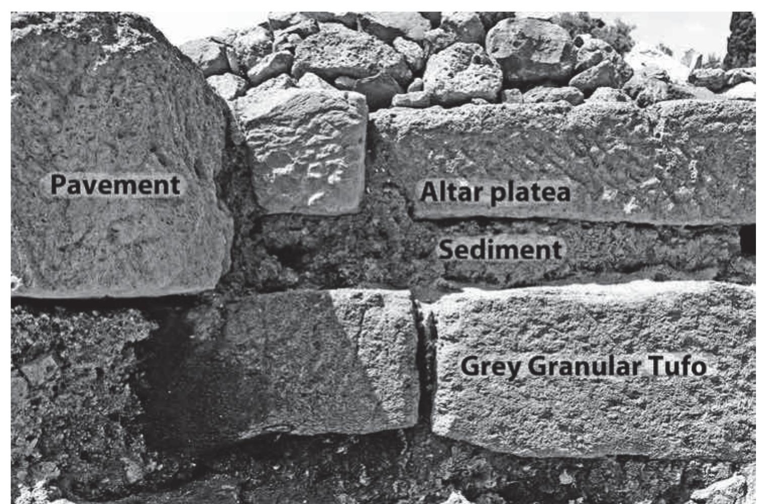 Fig. 11. Thin tufo lionato slabs of the platea west of the western altar, at right, abutting thicker tufo lionato blocks, at left, with course of grey granular tufo below (Author). 