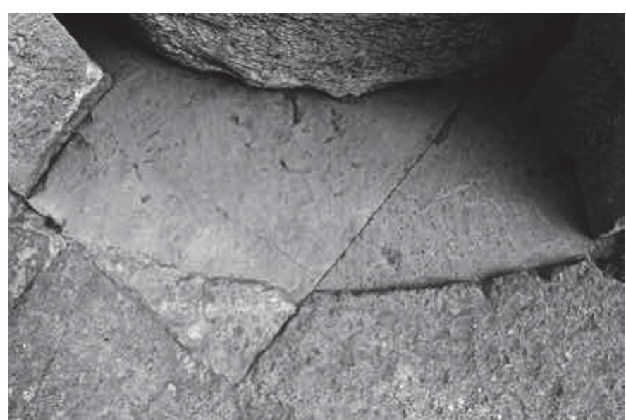 Fig. 16. Surface of tufo lionato blocks dressed for  insertion of circular monument (Author).  Ioppolo noted incisions on the top surface of the in situ lapis albanus blocks of the S. Omobon«  monument’s lower course” (fig. 18). These incisions run perpendicular from the outer circumfe g.  rence of the monument toward its center; they are evidently setting lines for the alignment of th  blocks of the upper course. Flanking these setting lines are pairs of small pry.  holes for  blocks into place. Ioppolo confirmed the former's utility as setting lines by using them  struct the upper course of the monument from the pieces that had been found diately adjacent to the lower course. Ioppolo seems to have placed the circu  dismant ar centra  hitting th to recon ed imme  block b  aligning a vertical incision on its outer diameter with the E edge of block I, as well as by noting area  where the anathyrosis had been touched up to follow the actual radius of the ad  1 11°: a ms | eo | 1° F al | 1 | oe 1°  joining b  ock®?,  a | 1 