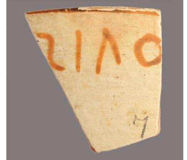 Figure 35. Chian pottery chalice fragment with pre-firing votive inscription naming the dedicant, Zoilos, c. 575-550 BC. British Museum, 1924,1201.820.  constitute the largest such corpus to date known from any site, and — as even tiny scraps with minute letter traces are preserved — probably preserve the near complete body of the inscribed material as encountered by the excavators. In addition to such graffiti or dipinti (i.e. incised or painted) inscriptions that relate to a vessel’s use or trade, there are also those inscriptions that are integral to a vessel’s decoration, which are invariably painted and known as ‘vase inscriptions’. 