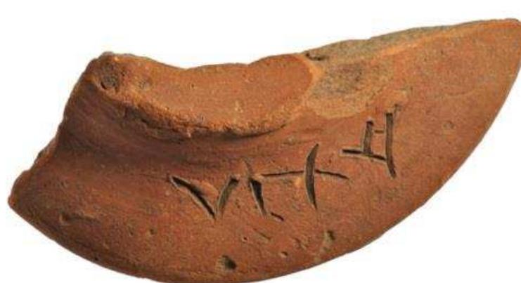 Figure 69. Ptolemaic kiln support fragment, terracotta with pre- firing inscription ‘Axi’, possibly 2nd century BC. British Museum, 1910,0222.233.  Figure 68. Iron saw from Naukratis, possibly 6th century BC. British Museum, 1888,0601.697. 