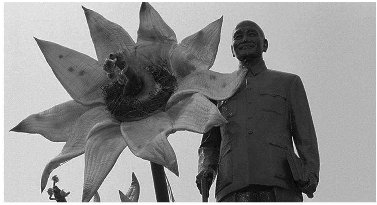 Figure 41  OU eee  What thus impresses in The Wayward Cloud’s musical numbers, which, like The Hole’s, reappropriate Mandarin 1950s songs, is this carnivalesque ethos, here updated through a high-camp aesthetic. The palette of colours is much more vibrant than in other Tsai films. Its musical numbers, featuring characters in outlandish costumes awkwardly lip-synching (often de-synchro- nized with the songs), are tacky, raucous, obscene. If grotesque tropes run throughout Tsai’s work, they generally lack the out- and-out flamboyance with which they are endowed here. In a way, this is a film which invites a retrospective look at his oeuvre for it crystallizes a number of grotesque motifs that, though per- vasive in his previous films, had not yet materialized with such  Phallic statue in The Wayward Cloud 