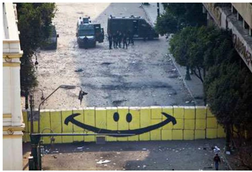 There were clashes on both sides of the wall: from the smiley face side, there were protesters, and from the other side, there were interior ministry forces. Stones and gas exchange from both sides and I am standing by the wall in the middle drawing a smiley face! (...) For me it meant, “you kill, we smile” We will not vanish and if the best you can do is to resist me by a bullet, then this smiley face is to tell you “show me the best you have got” (EZ, a 24-year-old male engineer). 