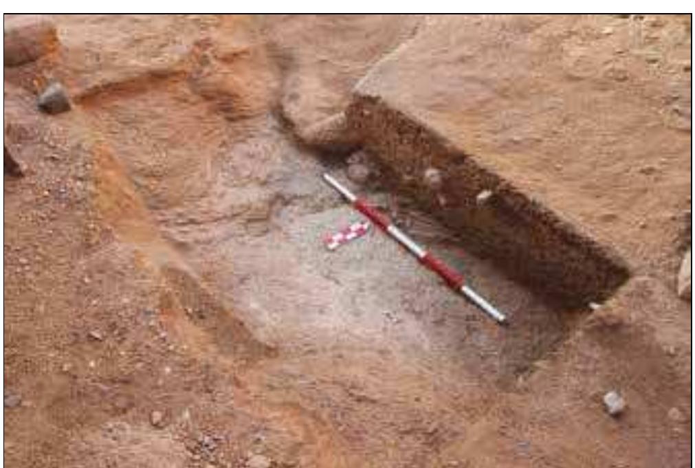 The last trench, Trench 9 (2 x 1m, max. depth ¢ 400mm) was excavated in the northern shelter where activities of looters between November 2014 and October 2015 ap- peared to have disturbed a human burial (see Plate 15).’ The excavation uncovered remains of one displaced skeleton of which only the terminal parts of fibula and tibia were preserved 7n situ (B.47), and an intact burial of an individual (B.46) in a contracted position on its right side with the head to the south west, facing south east, with bones in a state of preservation similar to that of the burials in Trenches 2  and 5-7 (Plate 12).  Plate 12. Trench 9 in the northern shelter with an intact burial B.46. View from the south east. 