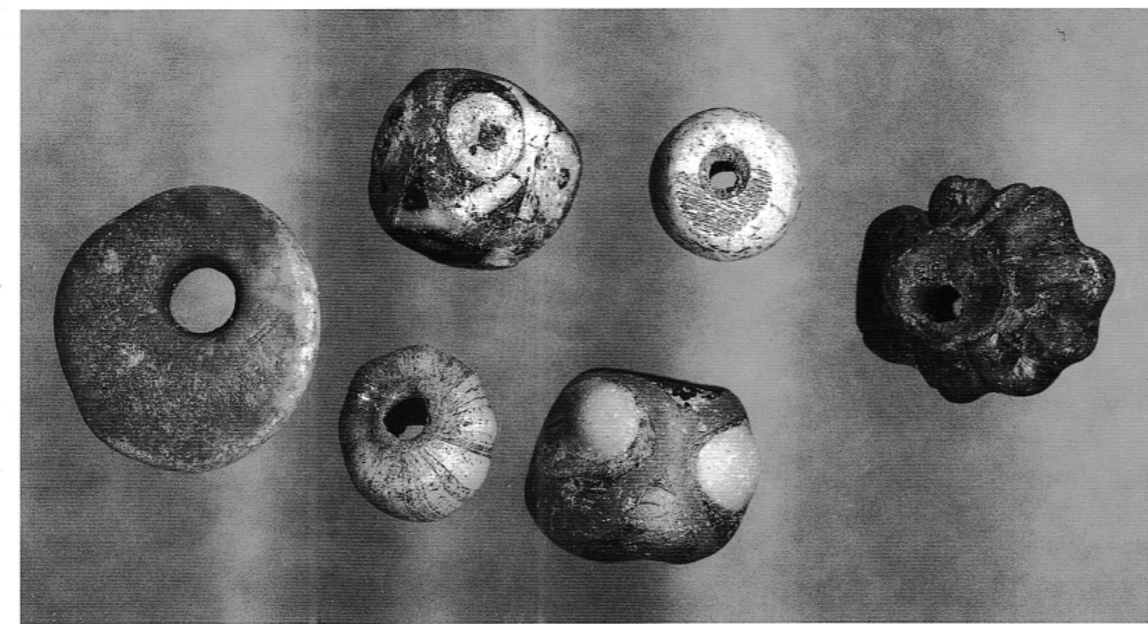 A selection of glass and amber beads.  ~ A large number of objects have been retrieved as single finds over the entire  Spillings area, wrenched out from the underlying culture layer by centuries of ploughing. Many of them, such as Scandinavian-style dress pins, jewellery and belt buckles, foundry scraps, etc. can be dated to the Viking period, while others have much later origins. A number of cons from the Viking Age up to the 16th Century have also been found around the excavation site. 