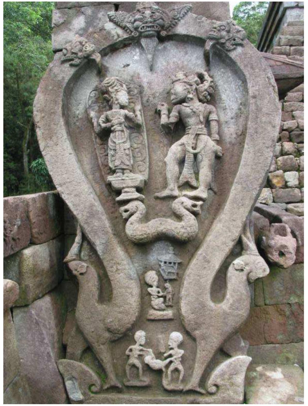 Fig 1. Relief showing the dialogue between Bhatara Guru and Bhima (Source: Wikimedia)  There is no indication of the time of composition of the Bhima Svarga in the colophon found in the extant manuscripts. Nevertheless, it would be interesting to study the iconographic context of Bhima in Java during the Majapahit period in a deeper manner through a relief at Candi Sukuh, a site located at the base of Gunung Lawu, which undoubtedly represents Bhatara Guru and Bhima (Figure 1). This large relief has the shape of a horseshoe traditionally believed to bear some similarity to the shape of a uterus. Each end of the horseshoe is carved in the shape of a stylised deer (Duijker 2010:176,179), 