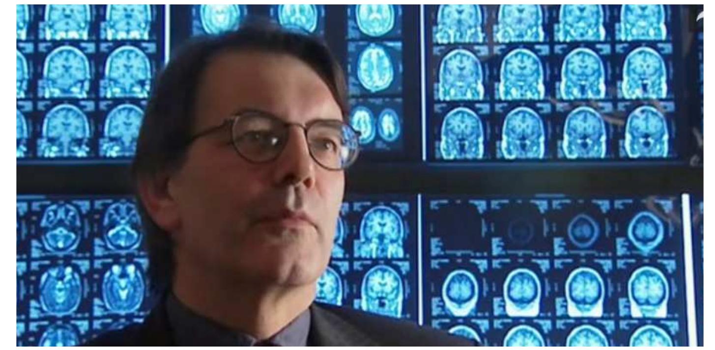 Figure 3: A screenshot from Brain Story (2004, BBC) and the first episode “All in the Mind”, where the neurologist John Hodges is interviewed in front of a large amount of brain scanning images. This background is supposed to give the viewers a contextualisation of the milieu Hodges works in.  The Brain as a Story in a Popular Science Documentary 
