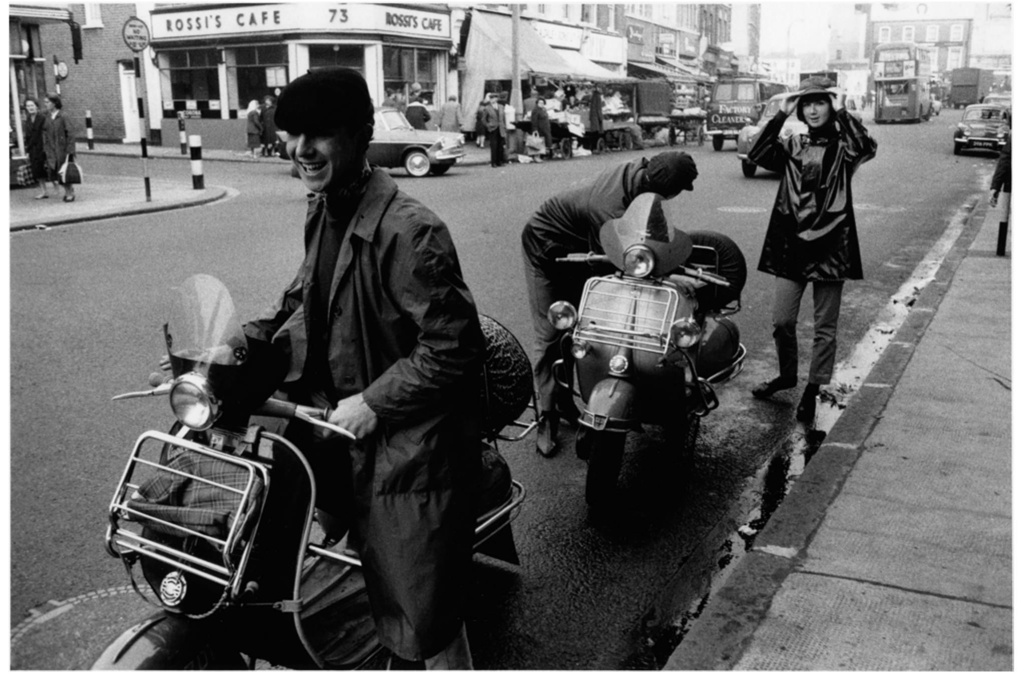 Image 3: Brixton 1963: Mods with their scooters, courtesy of Museum of London  It was also evident from discussions about what to wear in the office or while meeting clients that a significant proportion of users held professional positions. Discussions of holidays and photographs of users’ homes also strongly suggested that many users led middle-class lifestyles. At the same time, other users revealed that they worked in manual labour or service occupations. I found that the contemporary Mod subculture has a cross-class base, with class just one background factor rather than the determining one. 