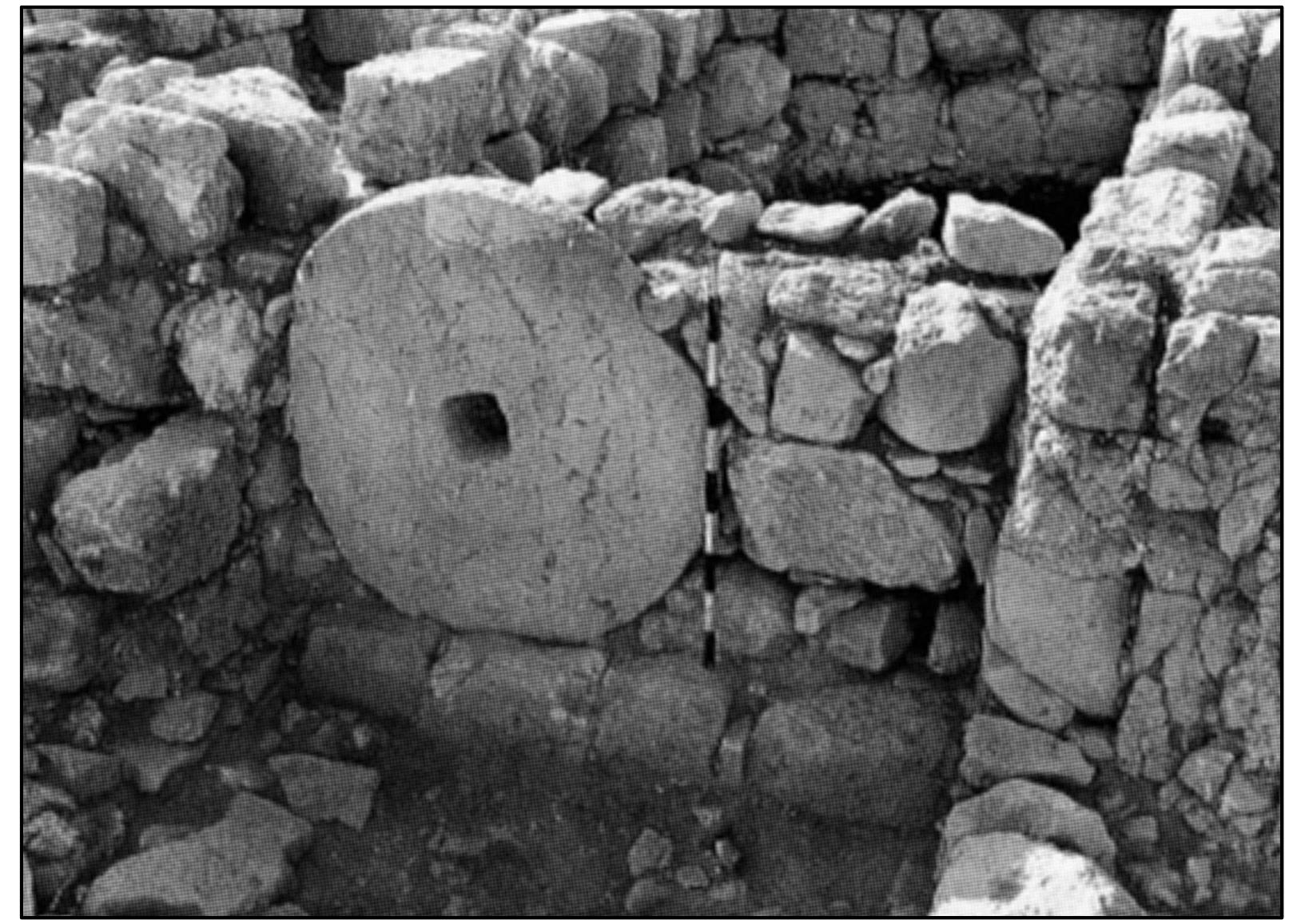 Plate 12. DeirGhazali: late divider wall with a reused oil press crushing stone (after Avner 2000, Fig.15; courtesy of the Israel Antiquities Authority) 