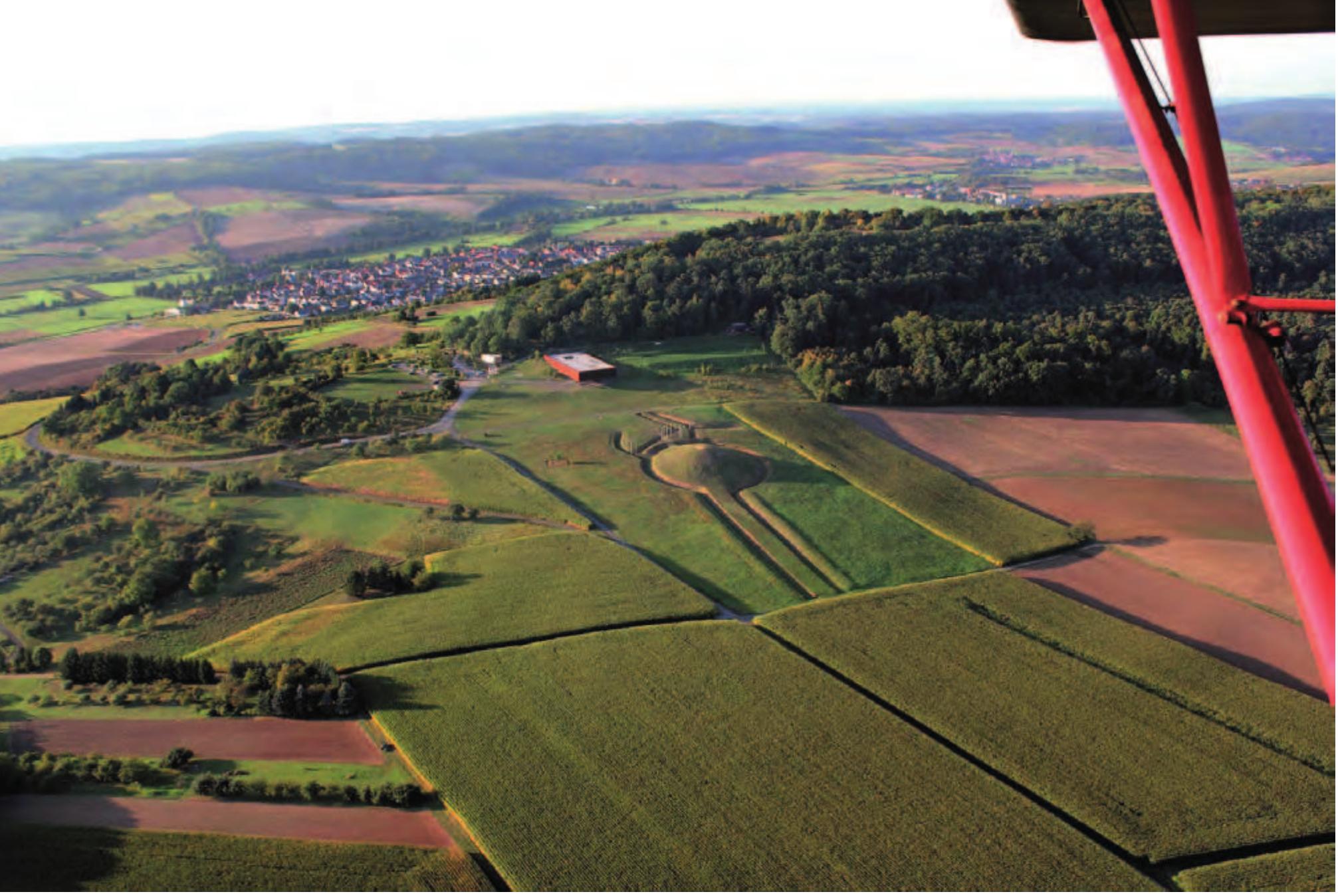 Figure 6.19. Glauburg-Glauberg: aerial photo of the rebuilt Tumulus 1 and the ditch-system with the so-called processional street (centre). In the background, the densely wooded Glauberg with the hill fortification (photo: Keltenwelt am Glauberg/V. Rupp). 