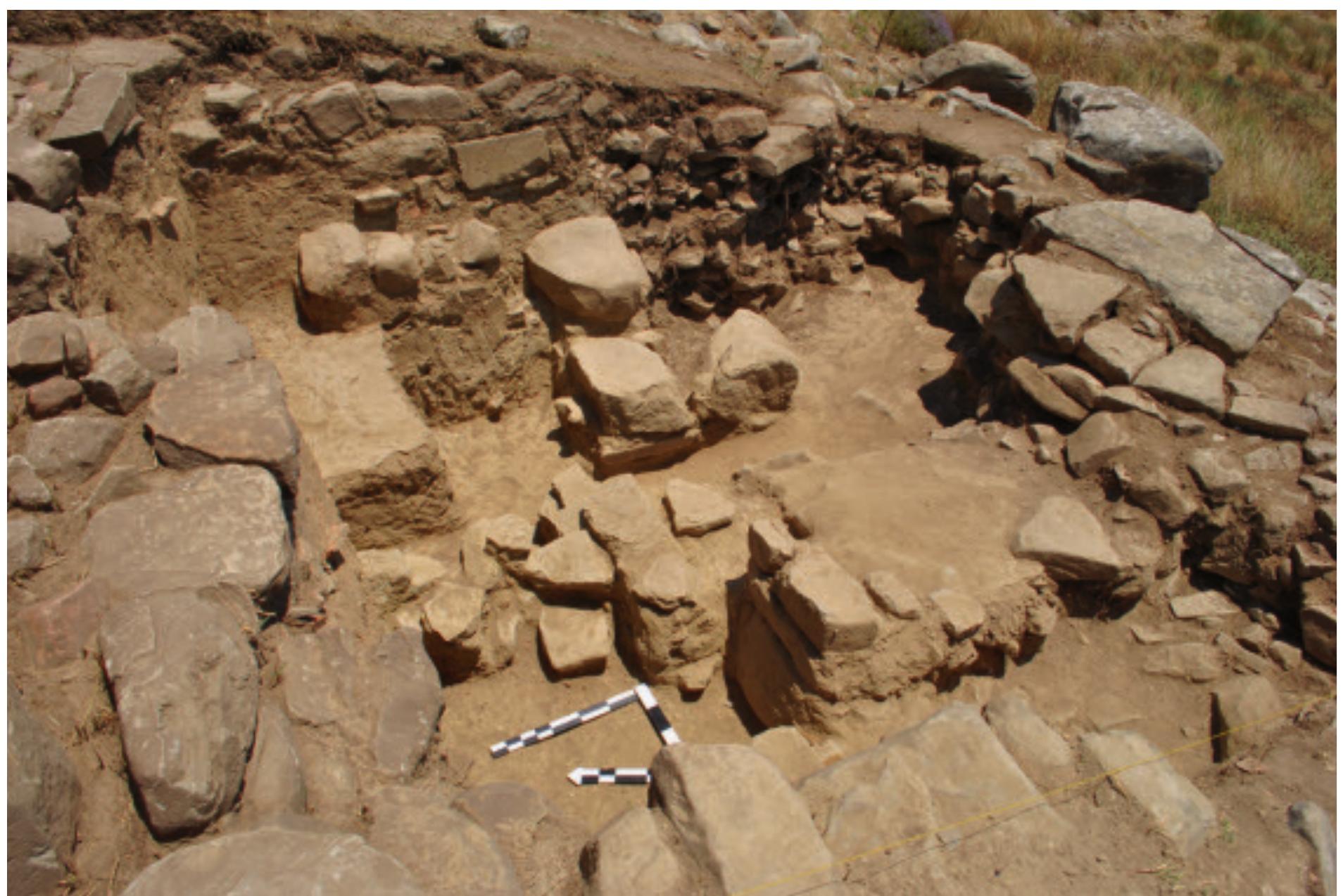 Fig. 19. Trench H30 at the Lower Acropolis wall; the rubble fill between the outer and inner faces of the wall is clearly visi- ble in the eastern section of the trench (Soren Handberg).  The Lower Acropolis Fortification Wall  with an inner fill consisting of stone rubble and earth. Traces of the inner wall, in the form of a single row of smaller blocks running parallel to the outer wall, were found in Trench H30. The inner wall has been much disturbed, and at most two courses may be recognized. However, it is clear that this row represents the inner face of the acropolis fortification wall. This is seen in the pro- file of the eastern section of the trench, where the fill of the wall is clearly demarcated (Fig. 19). The fill is tightly packed with stones of various sizes and a dark soil. To  the north in the profile, a completely different layer is clearly visible. This layer is of a pale brownish colour and completely devoid of stones. This layer (H30, Layer 3) is confined to the area north of the inner wall and did not  continue into the rubble fill. The complete section of the acropolis wall is therefore clearly visible in the eastern baulk. Layer 3, which abuts the northern side of the inner  A substantial wall constructed of rough, irregular-sized sandstone ashlar blocks in isodomic style surrounds the Lower Acropolis plateau and connects with the outer fortification circuit. In 2014.a single 5 x5 m trench (Trench H30) was excavated on the northern interior side of the wall, in a place where at least five courses were preserved to a height of 2.2 m (Fig. 18). Before the excavations were carried out, the date of the construction of the wall was unknown, but in connection with the fieldwork carried out in Kalydon in the years 2001-5, the then director had suggested that the wall might date to the late Archaic or early Classical period.?° The main aim of opening a trench at the wall was therefore to investigate the date of the construction of the wall. 