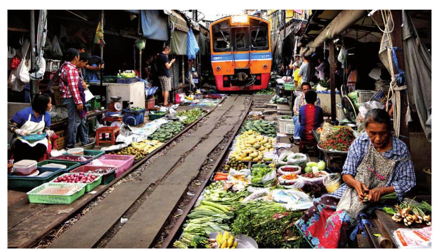 Maeklong Railway Market (Talad Rom Hoop) is an example of informal occupation of space in Mae Klong district, Samut Songkhram province in Thailand. The project situated itself or the tracks of a working railway line. The railway line is not completely idle. The commute! train goes by few inches away from vendors eight times a day. Through the engaging of the market makes this temporarily inoperative area interactive and unique (Fig 3).  Figure 3. street vendors In lalad Rom Hoop Market, I nalland. When the train whistle is heard, the vendors start to move their goods and shop awnings away from the tracks. The action of pulling down umbrellas has caused this market to also be called Talad Rom Hoop, which means the ‘closing of umbrellas’ in Thai language. 
