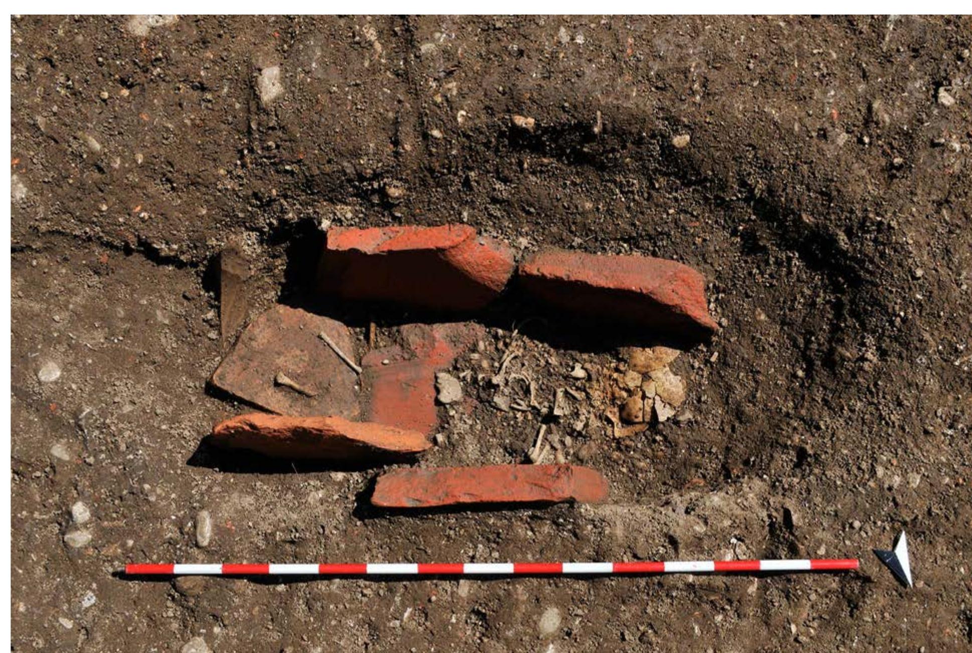Slika/Figure 5 Grob 1000, eden od pokopov novorojentkov na Kongresnem tren. Skelet brez pridatkov je pokopan v  konstrukeyi iz opek (foto D. Badovinac, arhiv MGML). / Grave 1000, one of the new-born burials in Kongresni trg. The skeleton without any grave goods is buried in a brick construction. Photo David Badovinac, MGML Archives. 