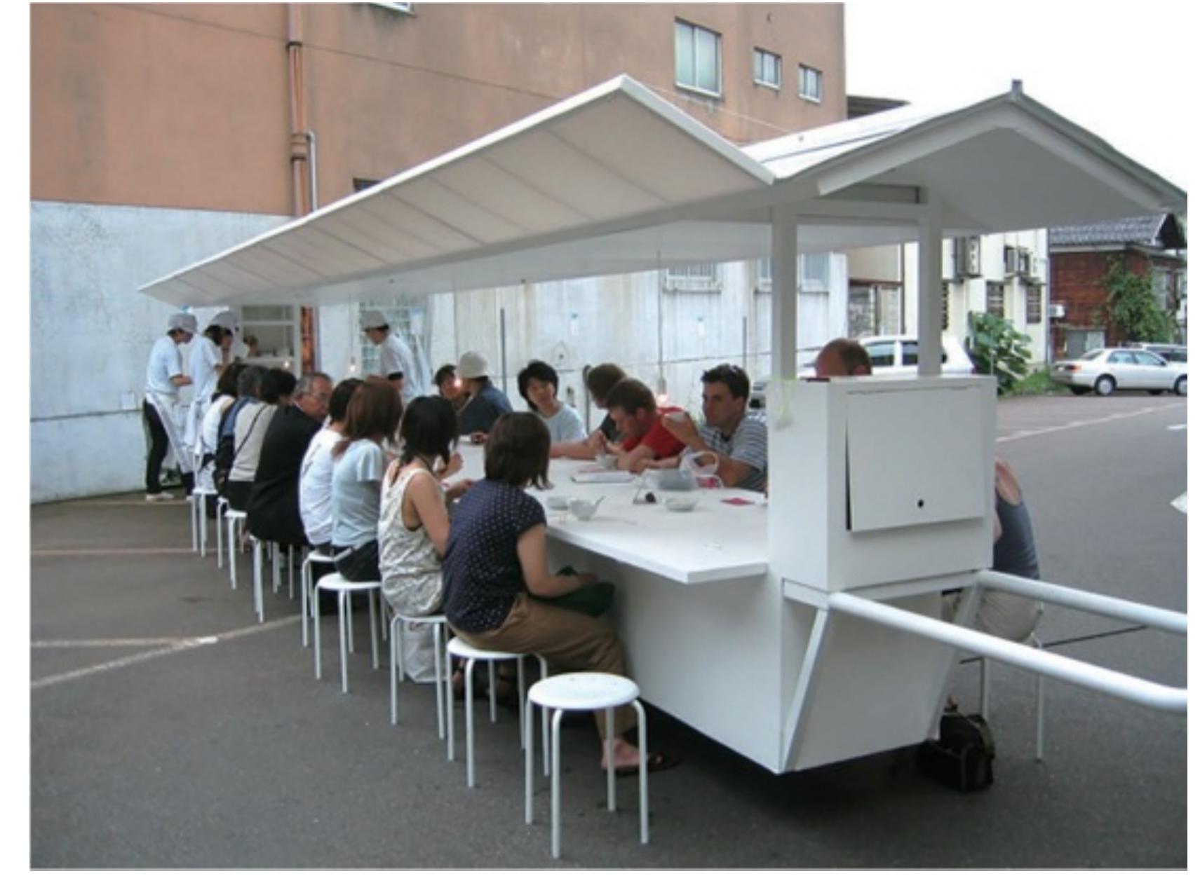scale of a banquet, encouraging the strangers seated together to interact over a meal..  described their work as ‘rearranging the ordinary’ (Betsky, 2006: 97). For example, Whit Limousine Yatai (2003), which takes the traditional Japanese ‘yatai’, or street-side food car and stretches it from its typical 1.5 metre length to 10 metres, following the model of th stretch limousine. In doing so the small-scale charm of the traditional cart is extended to th scale of a banquet, encouraging the strangers seated together to interact over a meal..  White Limousine Yatai, Atelier Bow-Wow, Echigo Tsumaari Art Triennale, Niigata, Japan, 2003. © Atelier Bow-Wow 