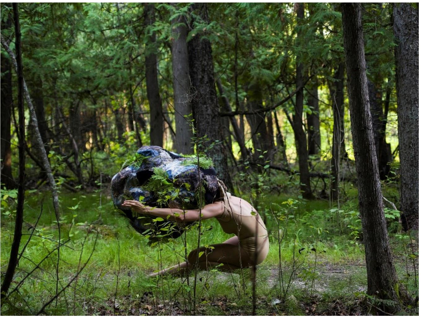 the self and the other, between identity and alterity. Rimbaud’s paradoxical use of language simultaneously upends and reasserts the split of the self anc the other. With this diaphanous notion of selfhood in mind, the videc Funambule recasts the hunter and the traveler from the “Erlk6nig” folktale as one being whirling around this interstitial space.  The French term for a tight rope walker, Funambule is a solo for a female dancer that moves between the open expanses of the grasslands to the dark shadows of a cedar grove, luring us to the heart of the forest. For this piece, contemporary dancer Arlo Reva embodies both the traveler from the “Erlkine” story as well as the malevolent creature that beckons the traveler to the depths of the forest. While rehearsing this piece, we developed a physical language for both characters. The traveler is portrayed by a female character weating a camouflage dress whose movements devolve from carefree, to more and more reckless and out of control, whereas the hunter is a jester of sorts whose uncanny silhouette is disquieting. The absurdity of the hunter’s movements is belied by the gravitas of her persona. As the crescendo of this frenzied encounter escalates and spins out of the field of view, the victor in this dogged struggle, between the self and the other, remains ambiguous. Within this narrative framework, Funambule intends to express the siren call of the stranger within, and as one attempts this path of 