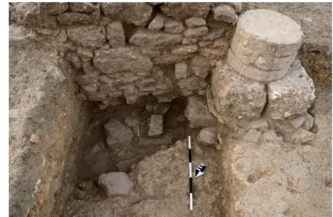 R. Souza — A. Walthall — J. Benton — E. Wueste — A. Tharler — B. Crowther — C. Schirmer @ Preliminary Report on the 2016 Field Season of the Americ Excavations at Morgantina: Contrada Agnese Project (CAP)  Work in Trench 43 revealed that the open court of Phase 1, possibly unroofed, was turned into a complex series of rooms and architectural features over the course of several renovations beginning in Phase 2. Tile collapse layers (Phase 4, below) found throughout this area indicated that nearly the entire northern half of the building was roofed in the final occupation phase (Phase 3). However, the evidence of the tile falls alone does not establish which spaces were roofed in Phase 2.  ene NN I EEE  The most crucial area of Trench 43 for the building’s architectural phasing is a brick column resting on a stone foundation that was dug into a floor at the corner where Walls M and X meet (fig. 14). The relationship of these different architectural components as explained below provides strong evidence for construction sequencing between Phases 2 and 3, and we have therefore split Phase 2 into two parts (Phases 2a and 2b) in order to reflect this sequence. The resolution of the datable material recovered does not yet allow us to establish a precise chronology for the two sub-phases, though Trench 44 also revealed construction activity that suggests Phase 2 should be subdivided (see below). Further excavation may provide sufficient evidence from elsewhere  in the building to promote these sub-phases to true phases in their own right, but for now we maintain them as part of a building-wide Phase 2. 