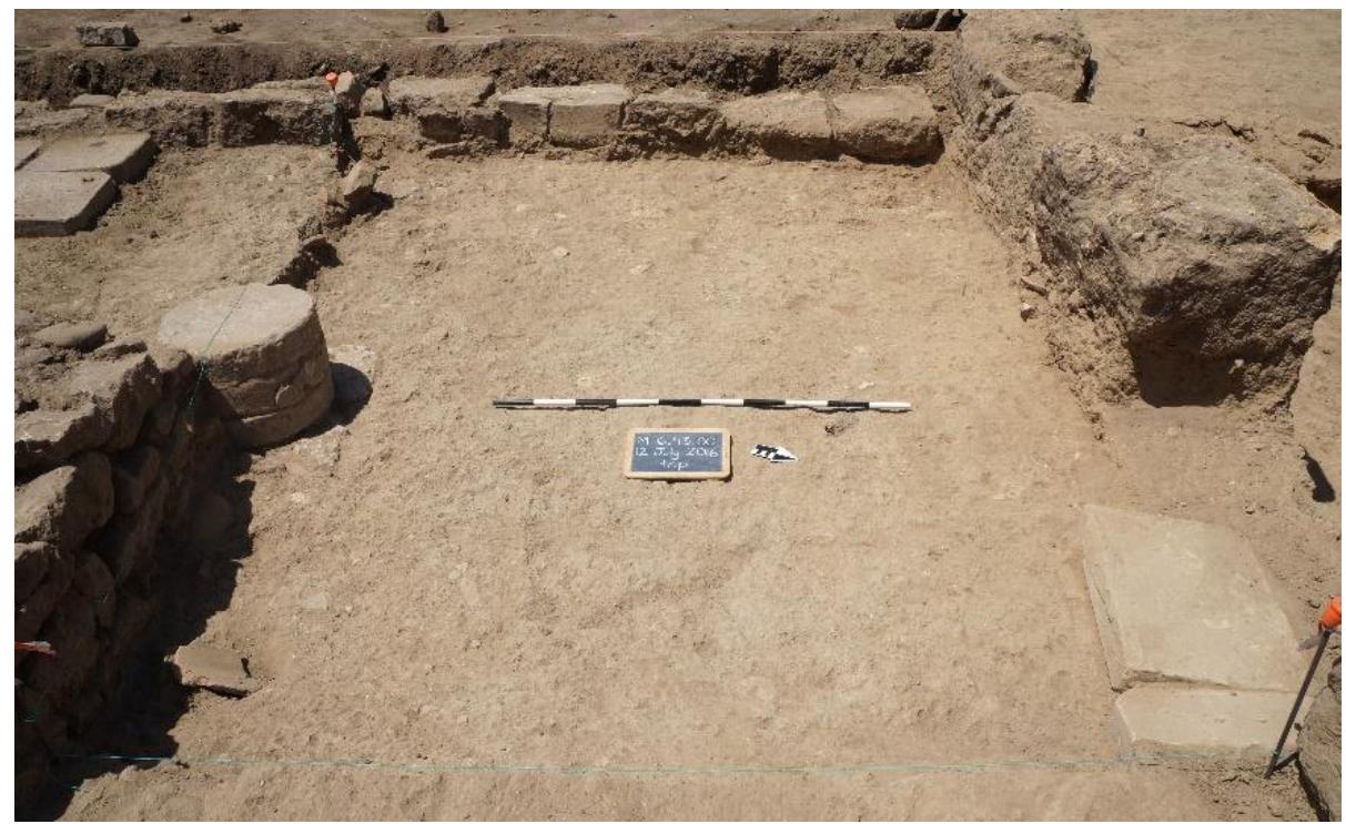 Fig. 16. Phase 2b crushed bedrock surface in Trench 43 (Room 6c), looking west.  Phase 2a floor (6043097) was cut to form a  hole that was filled with small stones and tile fragments, on which a foundation of two rectangular cut stones was aid to support a column consisting of terracotta drums (diameter 35 cm), of which three were found in situ (see ig. 14). At the moment when this column was installed, the surrounding floor was raised to the height of the tor of the foundation stones with a levelling fill capped by another crushed bedrock surface (6043084) (fig. 16). The eveling fill below this surface was generally devoid of inclusions but we did recover some fragments of black gloss pottery, including the base of a skyphos datable to the second half of the third century BCE, as well as < Syracusan bronze litra dated 240-215 (inv. 17-22; fig. 17)'®. We can thus propose 240 BCE as a terminus pos quem for this intervention and for Phase 2b itself.  