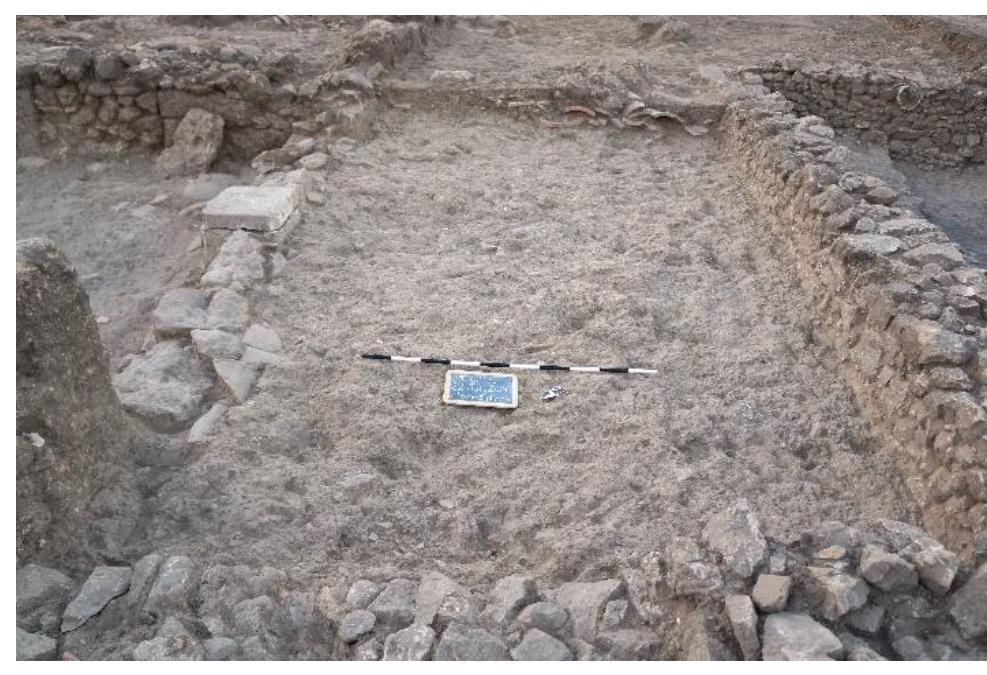 Fig. 26. Step between Rooms 10 and 11a with bricks embedded in Wall R1, and stone pier at far left, looking south. 