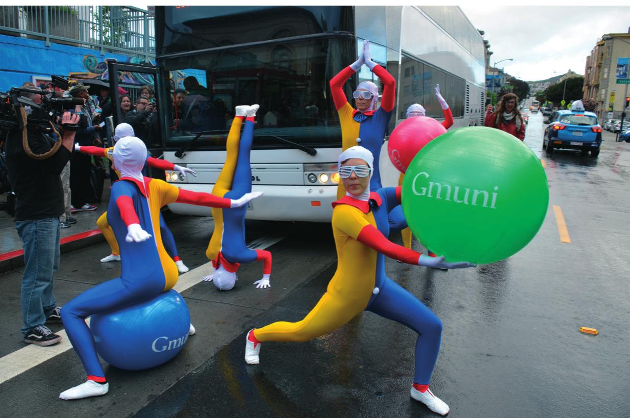 ™ Figure 2. Protesters dancing in front of a Google bus, San Francisco, 1 April 2014. Photo Steve Rhodes. Courtesy of Leslie Dryer  achieved by the tech industry. The tech industry may wish for smoothness in its buses operations in the city, and in its overtaking of urban space, and it may promote its shuttle systems as offering employees a smooth ride from their living quarters to their working quarters (with the WiFi-equipped shuttles themselves doubling as working quarters), but in fact the tech buses instantiate a new grid,  a grid of a privatized labour conveyance system that lies atop, and competes spatially with, the public transportation system (fig. 1).  > 