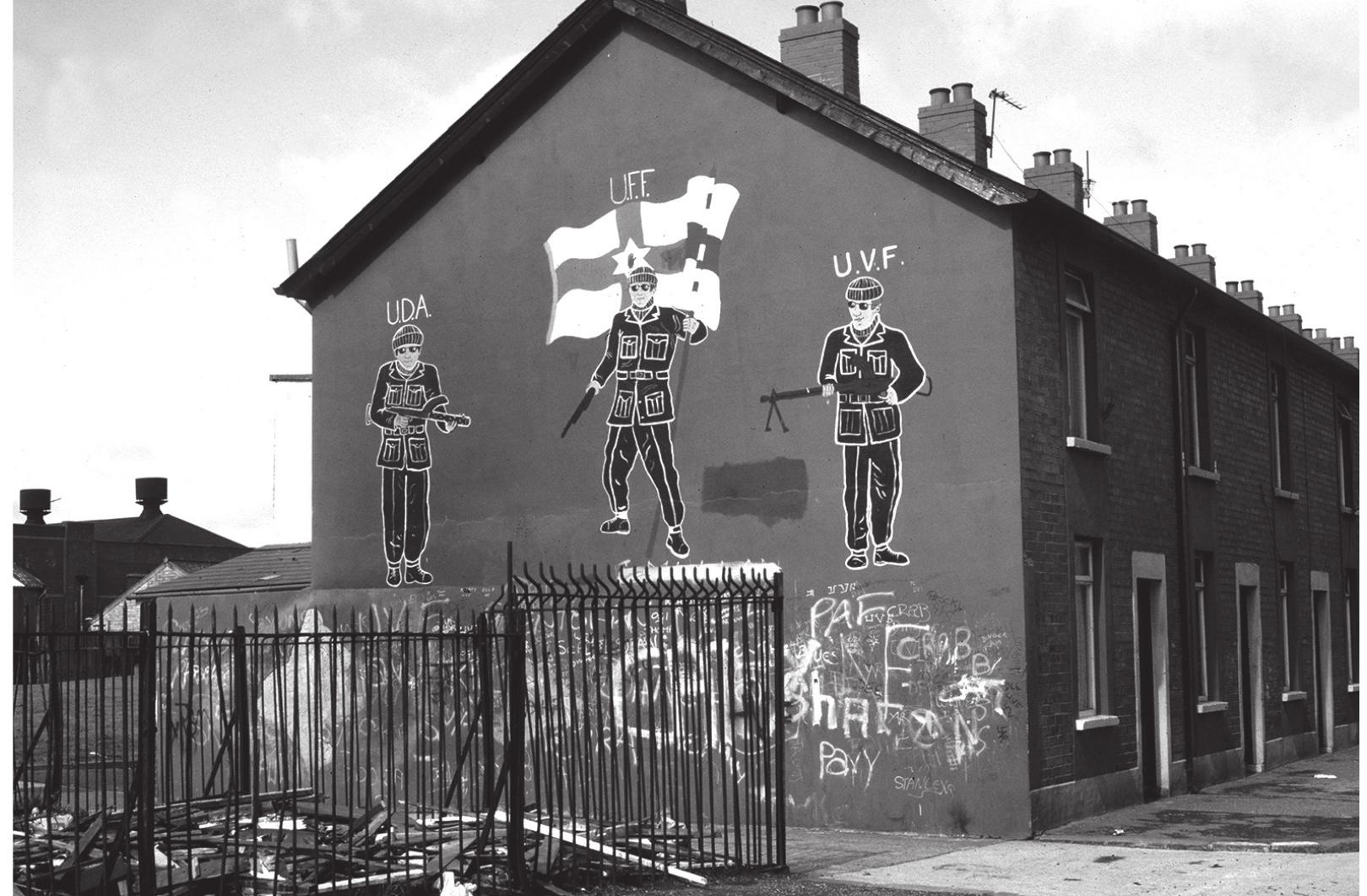 Fig. 4.3: Mural of armed loyalists, Severn Street, Belfast 1987 (Rolston 1991: 42). Courtesy of Bill Rolston  Similar sorts of alternation between generic representations and representations of more specific narrative can, I think, also be seen in Greece in the period between the early Late Bronze Age and the early seventh century BC. The anonymous scenes of chariots, or hunting and fighting which characterise the personal and often portable art of the Shaft Grave period, or the anonymous battle and funerary scenes found on pots associated with individual graves in the eighth century cemeteries at Athens (Ahlberg 1971a; 1971b), can be contrasted, on the one hand, with aspects of the more public art of the frescoes which adorned the Mycenaean palaces in the thirteenth century (to which I shall return below), or, on the other, with some of the scenes  
