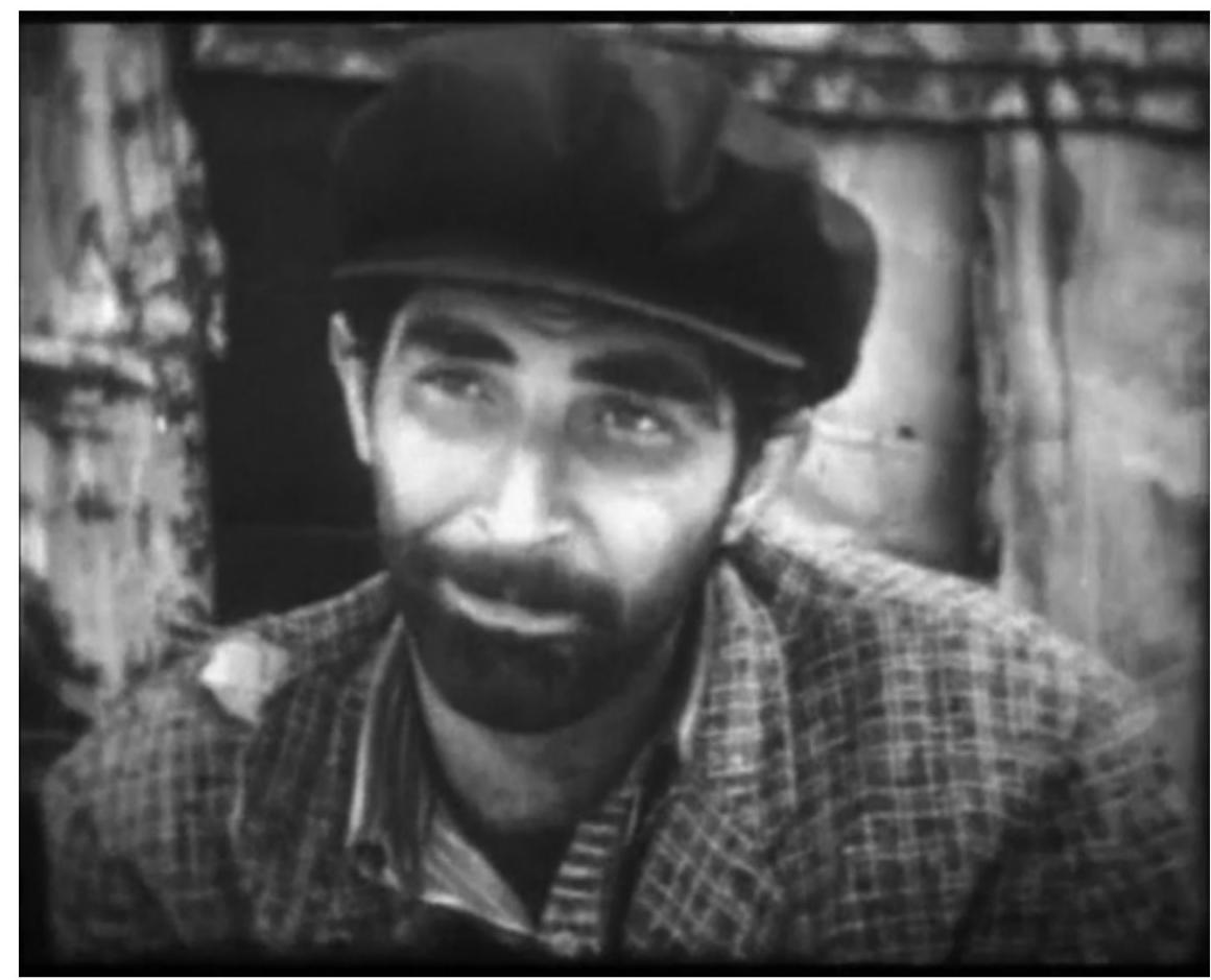 Figure 2. Frame from Al! Quiet (07:57). The poor homeless man (Erdal Ozyagcilar) in front of a wooden shack (courtesy of sinematek.tv). 