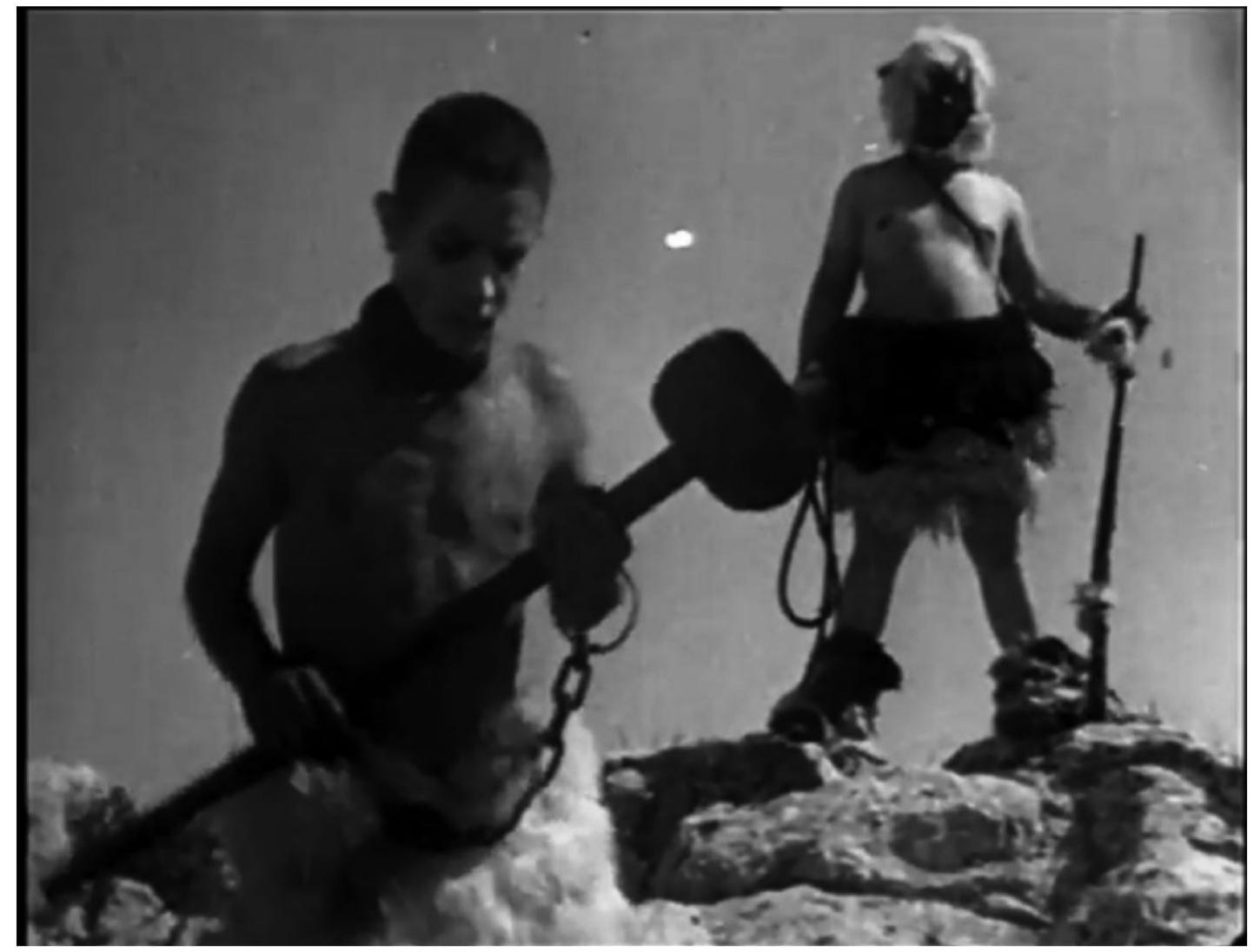 CALC ANN MLO 44h CEILS 2D NKSE OD F4AVSOE ALISO Aididl, L/UUUIEUEIN.  Deadlock represents a synthesis of the group’s investment in the politicé modernisms of the 1920s and 1960s, relying heavily on both intellectuz montage and grainy documentary images of the masses in their daily live to thematize conditions of hunger. The film cross-cuts between, on the on hand, a fictional narrative, which plays out as a master-slave relationshi between a grotesque, physically abusive masked figure and an enslaved bo in chains, and, on the other hand, clandestine observational footage of th police and the urban proletariat (Figure 4). The film’s “aesthetic of hunger gains momentum as soon as the beaten and starving child tries to eat th eftovers of his persecutor’s meal.’* But it gathers full force whe:  