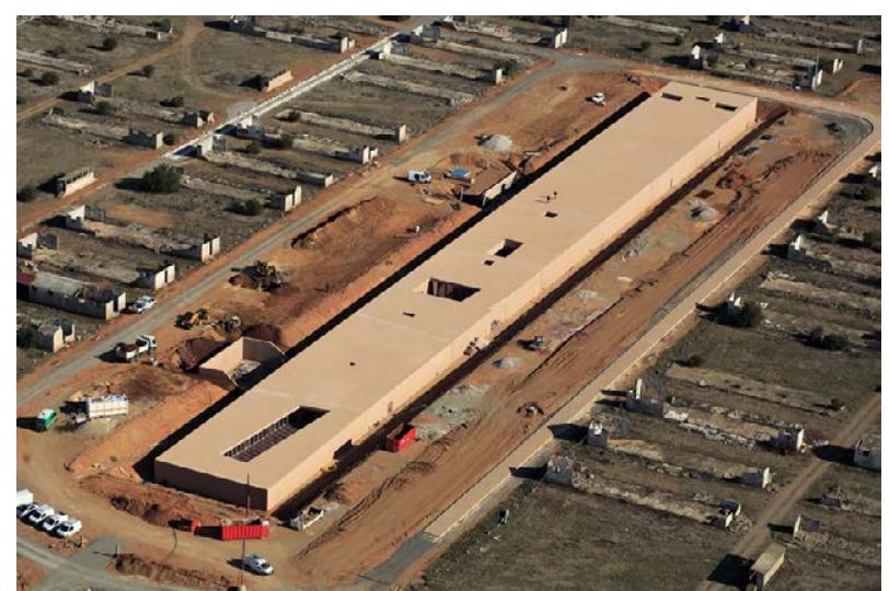 The Rivesaltes Memorial Museum was designed by architect Rudy Ricciotti and comple  2015 (Fig.3). This museum on the  site of  ed in a for-  mer French military and internment camp near  Perpignan, France. Emulating the s lar barracks of the camp, burying it  im rec  angu-  o the ground  like a coffin with a clear reference to the how the camp and the war operate, Ricciotti chal  the cultural memory site while rewri of the museum through architecture  uation of the slightly and dramatica  enges  ing the story . The contin- y illuminated  blind walls inside creates a dark and whelming  Fig. 3 - Rivesaltes Memorial Museum (©M. Hédelin / Région Languedoc-Roussillon). 