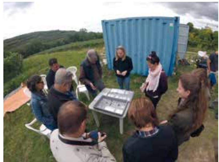 Fig. 21 Studying finds on the site of Kammern Grub. graben (photo: F. Ostmann/OREA)  After an introduction to the geography, the geology and the history of research, the excavators provided an insight into their new results and latest finds. Impressive new insights into past life were given by explaining a special feature interpreted as a possible ‘meat cache’ and the unique opportunity to see such a structure at first hand and in situ (Fig. 22). 