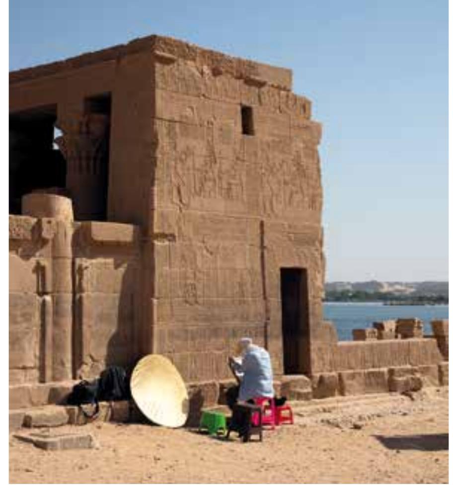 Fig. 79 Collating our facsimiles of the soubassements (or dado) decoration at the base of the exterior lateral walls of the pronaos of the Temple of Hathor (photo: H. Kockelmann) 