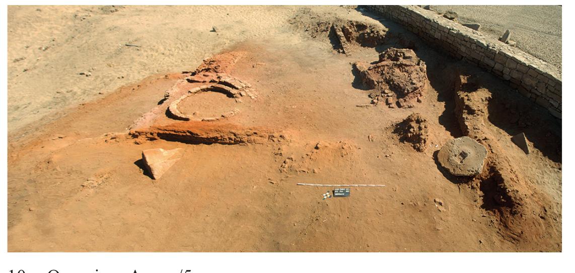 The structures consist of two  parts of a large storage facility (fig. 7  of the area was a complex of three adjacent courtyards, eac  southernmost courtyard of these two rectangular and a curved wa  2.95 x 2.60 m) is of roughly triangu 1); its ground plan is fully preserved.  has a diameter of 1.75 m. The adjoining northern courtyard exposed in 2017*%. The third courtyard, formed by a massi  and a much thinner northern-sout also only partly excavated in 20  hern wall, and its granary  7.  OE NO Ee ee  h containing  ve east-wes  . In the northern part a round granary. The ar layout (formed by The granary within it  and its granary were only partly  wall (width 1.25 m)  estimated d  iameter 2.20 m) were 