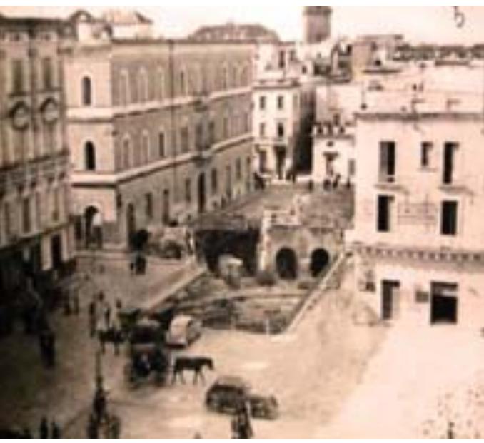 Fig. 5: Gli scavi archeologici seguiti alla Costruzione del palazzo della Banca d’Italia al termine delle opere di musealizzazione (elaborazione di Luigi Paolantonio da Montinari 2018)  archeologiche Cosimo De Giorgi, vero e proprio pioniere dell’archeologia a Lecce (D’ANDRIA 2004, 41). Nel 1873, i lavori sulle fondazioni di casa Greco consentono di notare come il prospetto parallelo al lato sud del Sedile sia fondato su di un muro a secco di blocchi ortogonali in pietra leccese, mentre lo scavo di una cisterna rivela un ambiente sotterraneo con quattro archivolti. Ai primi del ‘900 vengono finalmente alla luce i le tracce dell’anfiteatro, a seguito dei gia citati lavori di realizzazione del Palazzo della Banca d’ Italia. L’lsola del Governatore, composta da fabbriche eterogenee, risulta in tale stato di degrado che si ritiene piu. conveniente demolirla anziché restaurarla attraverso un intervento estremamente complesso. Come esito della prima alterazione del continuo gravitante sull’anfiteatro, l’indagine archeologica all’interno del centro antico esordisce con uno scavo a forma di “L” dell’estensione di circa 1.300 mq, di seguito recintato e musealizzato in modo da creare una definizione che caratterizzera |’ambito per circa 20 anni. 