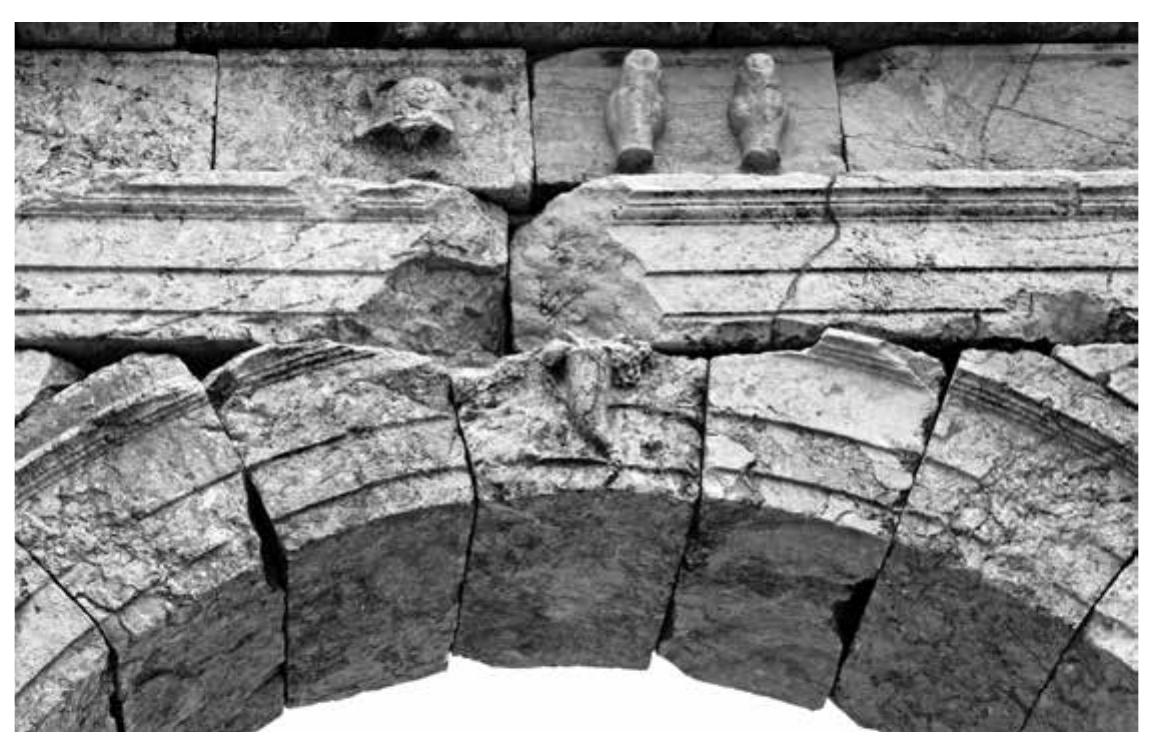 people®. That this symbol of prosperity can most probably be linked to the shrine is also sug- gested by the situation of the latter, half way on the axis between these two entrances to the agora. Gates are known to have been decorated with the symbols or effigies of deities whose sanctuaries lay on the road leading away from the gate: the relief of a double axe — the symbol of Zeus Labraundeus — features on the »Gate of the axe« at Mylasa in Caria leading to the sanctuary of Labraunda, and the busts of Leto, Apollo and Artemis are present on the Vespasian city gate of Xanthos leading to the Letoon®™.   ~  Other elements of architectural decoration included weaponry friezes imitating those found reused at the late antique northwestern gate of the city and probably originating from the preced- ing Hellenistic city gate, which are seen as a reference to the warlike reputation of the Sagalas- sians*”. Two defining elements of the community’s identity — prosperity and power — were there- fore represented on the arches, creating an ideological axis along the south edge of the square. Furthermore, the gates were a spatial expression of the new ties that linked the Roman emperors to the fortune of the city. The urban community of Sagalassos had from the early Roman Impe- rial period explicitly expressed its loyalty towards the newly established regime, using inscrip- tions which articulated its allegiance, as well as incorporating urban elements throughout the townscape which conveyed its understanding of the new world order**. Expressions of loyalty towards the emperors through dedicatory inscriptions were one way for a city to establish, iden- tify and represent itself as part of the Roman Empire. The buildings or monuments that these dedicatory inscriptions were connected to, in this case triumphal arches, were picked from the well-established architectural language of the Roman world. The suggested association with Tyche through the symbol of the cornucopia would therefore also reflect on the position of the Julio-Claudian dynasty at Sagalassos, as the guarantor of good fortune for the city.  