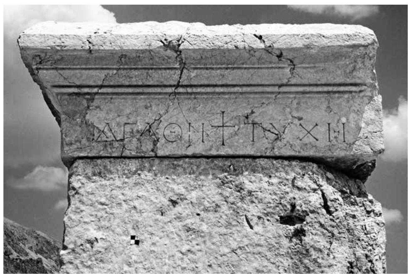marking the southeastern entrance to the Upper Agora (Fig. 22). The two words were arranged on either side of a nicely carved Latin cross, indicating the Christian nature of the text as well as the Christianization of the monument, and placing the passage of those frequenting the agora under the protection of the Christian God. The exact date of the inscription is difficult to as- certain on the basis of letter shape alone, but comparison with the aforementioned Panhellenios inscription dating to the 370s and a mid-5" century inscription for the influential general Flavius Zeno (floruit 447-451)! suggests a date closer to the former. In any case, a date between the late 4 century — the end of the polytheistic city — and the early 6" century — when inscriptions used  completely different forms of letters — seems certain. This would make the inscription the first known public Christian element on the Upper Agora.  bad  The fact that an arch, a structure which expressed power and triumph, got a Christian char-  acter through the symbol of the cross, was quite telling for t  he new status of Christianity. It  publicly declared the community’s commitment to Christianity. The use of a typically pagan  introductory formula with explicit reference to Tyche, thoug  h, is equally striking. Beneficent  female personifications such as Tyche are known to have remained a popular presence in the late antique households. While many of these personifications alluded to moral qualities and  may have had Christian overtones, they also invoked materia (Soteria), as well as physical prosperity (Agathé Tyché)'?. But h in a public context, as part of an official monument’. The s  wealth, prosperity and security ere we see the concept being used hort inscription clearly indicates  