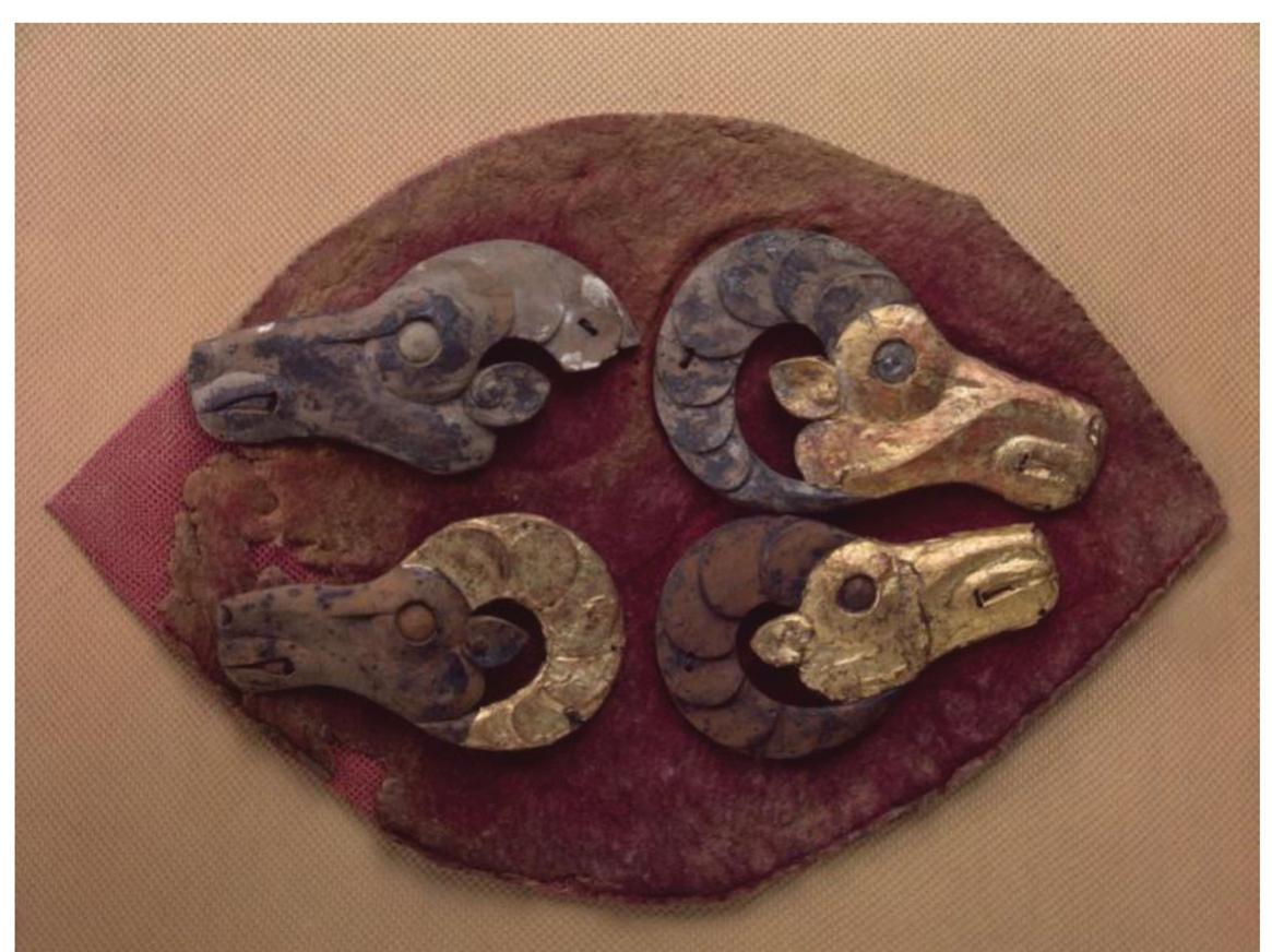 animal-derived product in nomadic communities, but also featured abbreviated antler motifs, echoing nomadic visual tropes (e.g. meto- nymic representation). Figure 8 exemplifies a local textile—a saddlecloth is decorated with antler configurations alluding to the presence of deer—a typical visual synecdoche. A similar configuration is found on a fragment of a felt covering featuring images of mouflon heads (Figure 9). Other saddles are adorned with scenes of animal combat or  is decorated with antler configurations alluding to the presence of  Figure o Saddlecloth. Felt with appliques. Pazyryk Barrow no.5.  Image is used from www. hermitaqemucim org court 