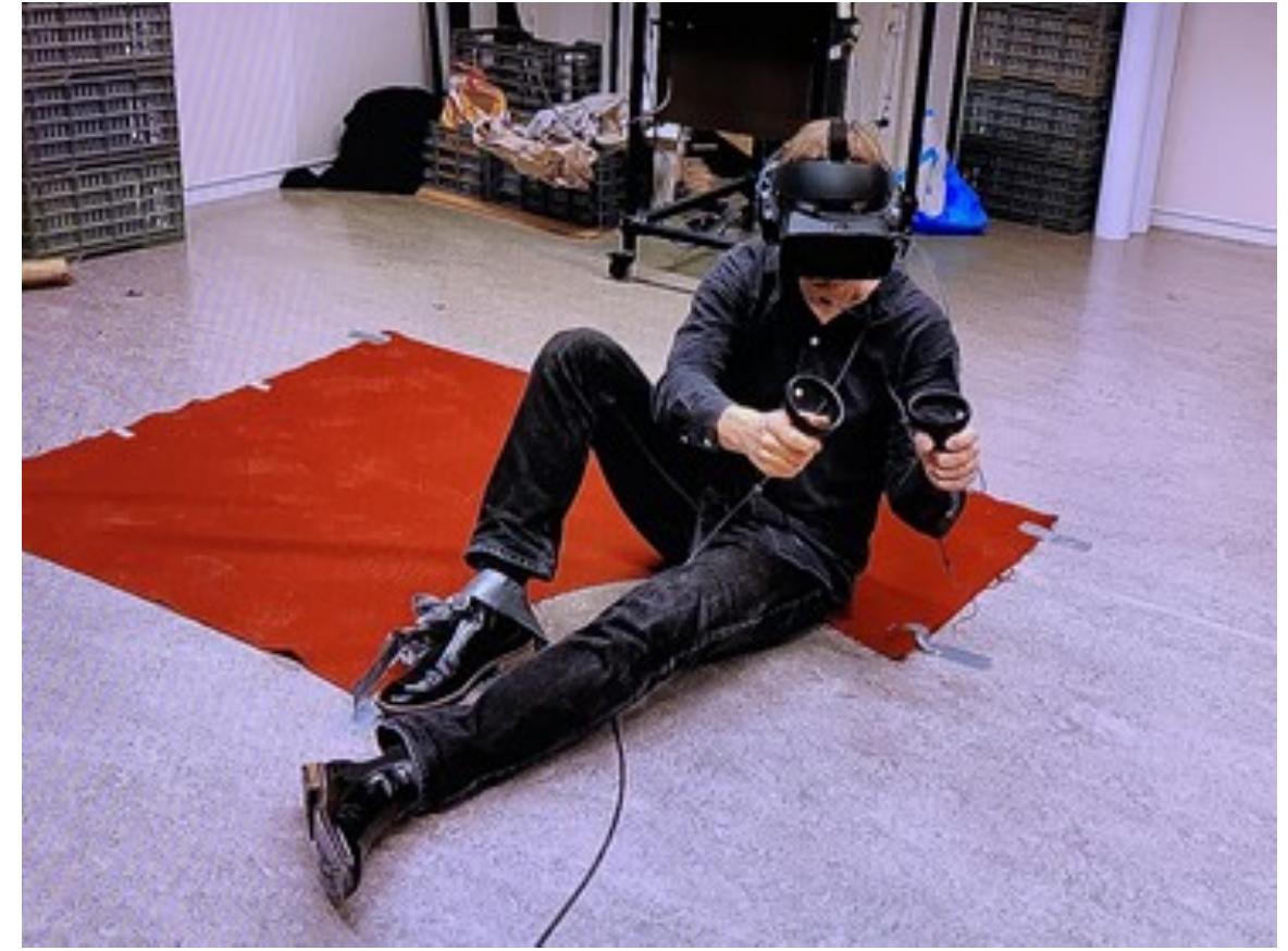 experience is that the interactor is an agent tasked with retrieving data from a computer for their remote instructor. However, upon entering the building, an earthquake happens, burying the interactor under debris. To convey this situation, students fixed the interactor’s right foot to the ground to create an experience congruent with the player character being physically restricted (Figure 3), thus also limiting the range of interaction. Only after solving a series of puzzles, for instance by combining objects to reach a switch, is the interactor set free. Play testers and evaluators were impressed with the resulting embodied experience. This project showcased how a seemingly simple design choice can have a strong impact on the user experience. 