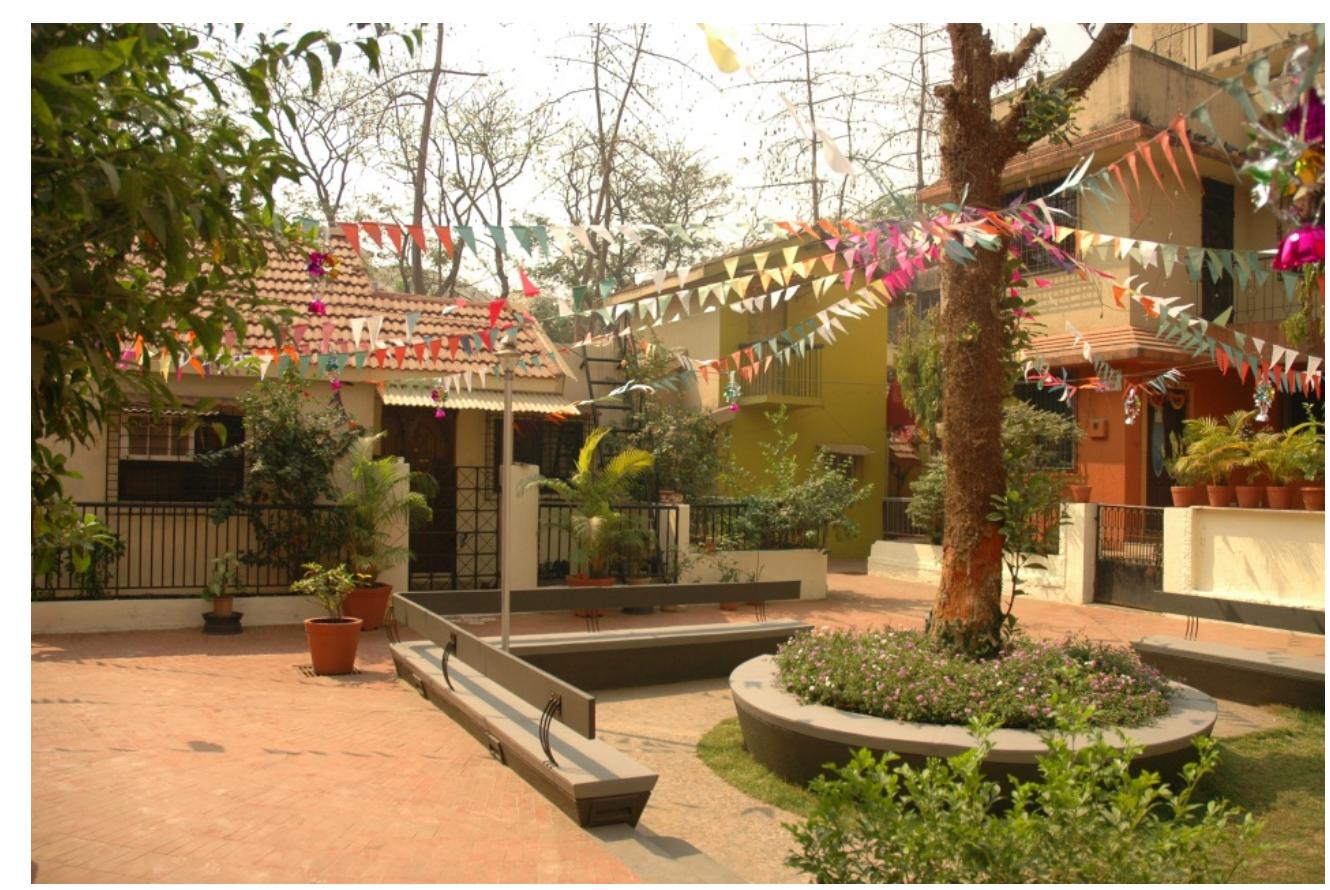 The most important take away from the project however is twofold. Firstly it allows for a demographic mix and homes to grow based on income — incrementally. A mix such as this make for more sustainable communities and introduces the social as a critical factor in any determination of what might be a sustainable city. Secondly, the project shows the rich possibilities for design when there is a shift in the frame or scale of our gaze and the “compact” can also find a place in the broader regional planning dimension. Here the location and access to public transportation also demonstrates the crucial role that it can play in determining urban form. In fact, as illustrated by this project, public transportation is probably the best form of indirect subsidy on housing. For, it opens up affordable land in the region and in the process opening up new possibilities for an array of housing types. Thus resituating and giving architecture agency in the planning of the city.  Image 14: View of the common space in a typical cluster. The low rise high density configuration of this housing type creates a great sense of cooperation between the residents photo credit Rahul Mehrotra) 