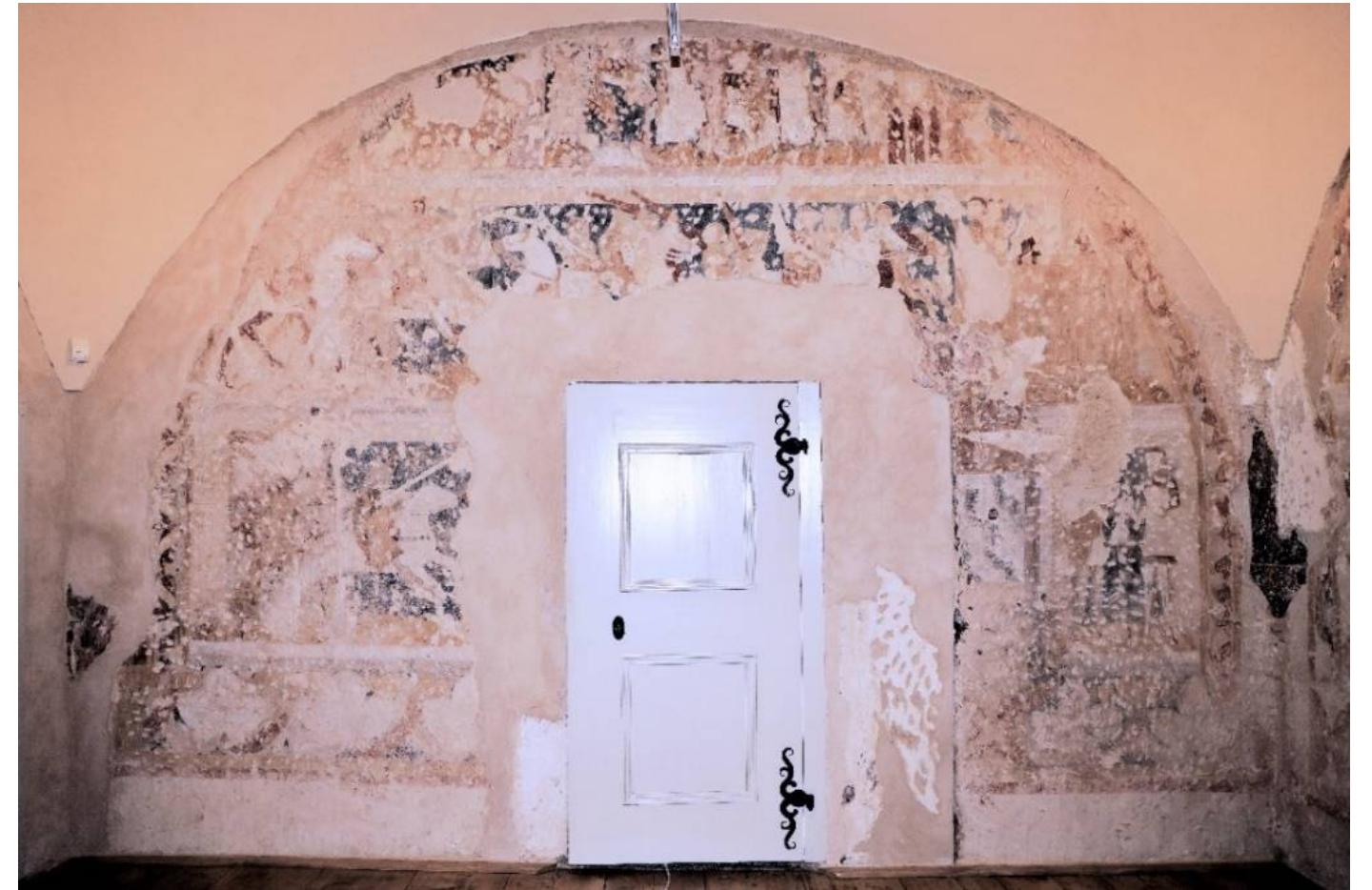 Figure 20. Kun&tat, castle. The northern wall of the room with the knight’s cycle (probably the Knight’s Ride of Gahmuret with the Battle of Batellamunt). 1st half of the 14th century. Photo by Franti8ek Zaruba, the author’s own work.  The paintings in the Moravian castle of Kun&gtat are slightly younger. At the time of their creation, the castle was owned by a member of the Moravian elite of the period, Gerhard of Kun&tat (Beranek et al. 2017, pp. 401-16; Zaruba 2021a, pp. 100-2). Again, the  painting cycle was created in  he palace building, more specifically in a vaulted chamber.  The paintings originally covered all four walls, including window and door recesses  (Figure 20). However, today t  he decorations are largely destroyed; only about half of the  original cycle has survived. The representations are arranged in three horizontal strips with the individual scenes not clearly separated. They undoubtedly illustrated some courtly  epic, perhaps scenes from Wo  fram von Eschenbach’s chivalric romance Parsifal, or more  precisely motifs from its first two books, devoted to Parsifal’s father Gahmuret. This identification is possibly indirectly supported by the representation of an anchor, a motif  which played an important ro  e in Parsifal (Figure 21). 