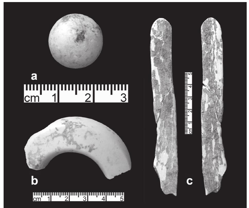 15. (a) Polished stone sphere ‘token’ from W-80 Later LN phase pit between central pillar and south-west doorway; (b) ‘mace-head’ fragment from foundation deposit around base of W-80 central pillar; (c) bone spatula from founda- tion deposit around base of W-80 central pillar (photogra- pher G.O. Rollefson). 