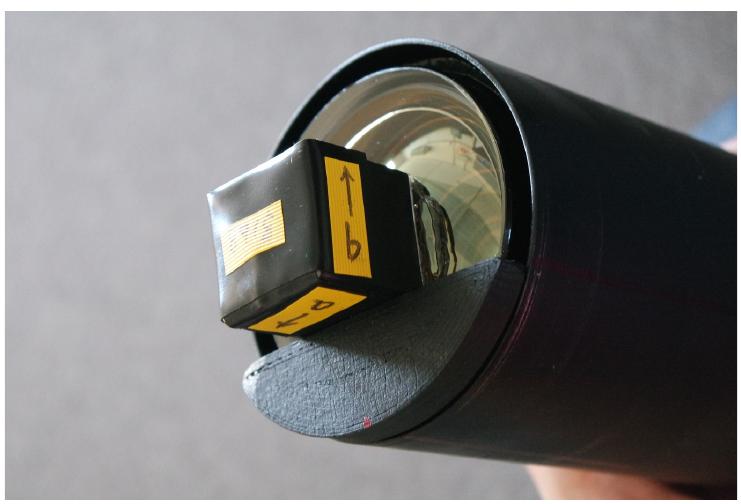 Fig. 1. Wrapped stilbene crystal positioned against a plastic guide and mounted to the PMT face with optical grease. 