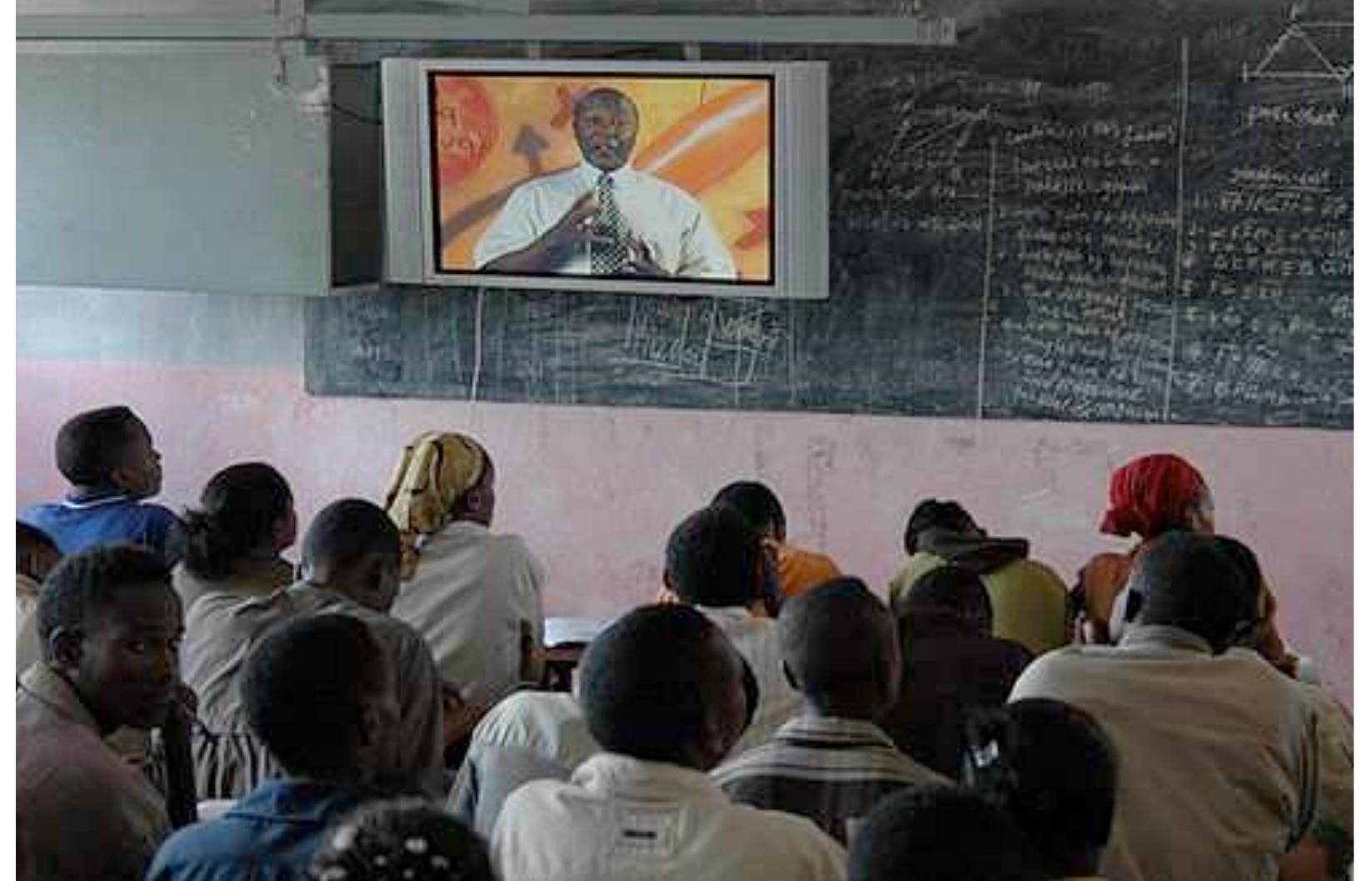 Figure 1: Live “plasma” transmission in a government school classroom Source: Heavens, 2005. Copyright Andrew Heavens of www.meskelsquare.com Reproduced by permission.  transmission improves the listening skills of the students; and on the other hand, they said also that the students are spending their instructional time in listening. For a skill to develop, a certain period of time will usually be spent. However, here, the contexts of the responses were different. When the participants say, ‘most of the students’ time is spent in listening’, they indicate the presence of many more equally important and key learning skills to be developed. They, for instance, mentioned the need to get time for student-teacher and student-student interactions so that the students’ level of understanding of the contents will improve. In doing so, their communication skills, not only listening, but also speaking skills, and thereby their ability to think critically, have a better opportunity to develop.  