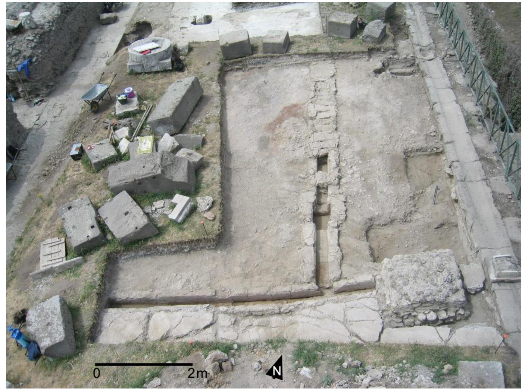 Fig. 16. View of the lime mortar surface of Phase 2b (2912) as exposed in 2006 in Curti’s Trench IIS (Photo: M. Mogetta). Note its associ- ation with the drainage channel and lavapesta pavement to the S. 
