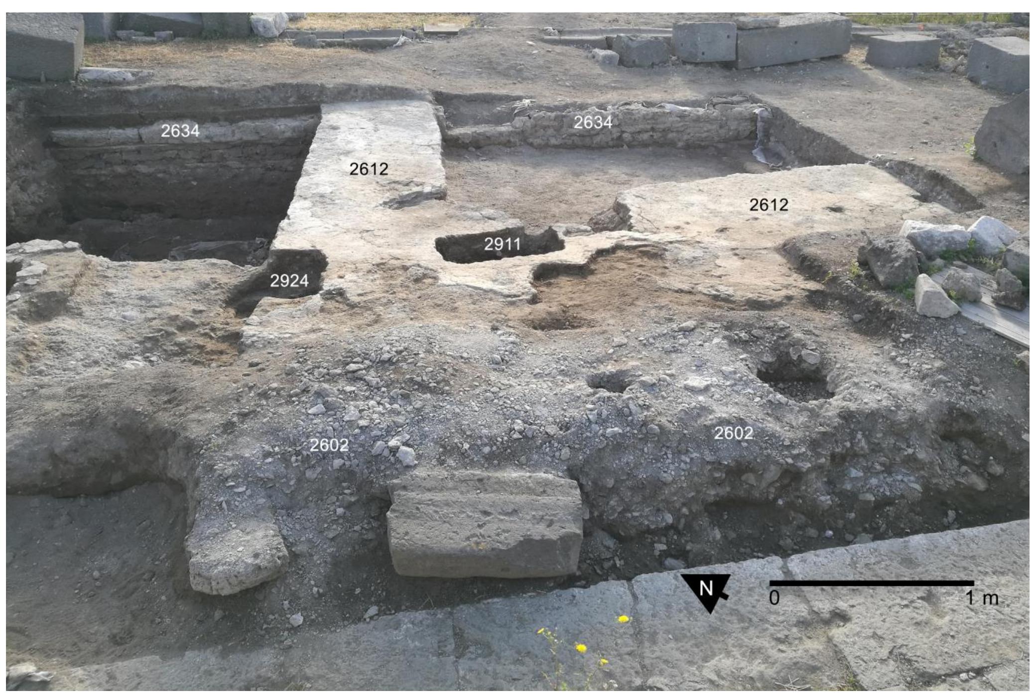 No evidence predating the construction of the existing temple was detected in this sector. Phase 2 strati raphy and finds refer to the establishment of the temple podium in the Augustan period and document subs quent modifications in the Julio-Claudian era. Phase 3 features belong to the Flavian reconstruction of the p  dium.  Fig. 18. VPP 2018, Trench IIS-W: General view (from W) at the start of the excavation. Note the Flavian-era lime mortar surface (2612) and the concentrations of waste materials (2602) filling the foundation trench of the trachyte stone blocks of the Phase 3 temple (Photo: VPP). 