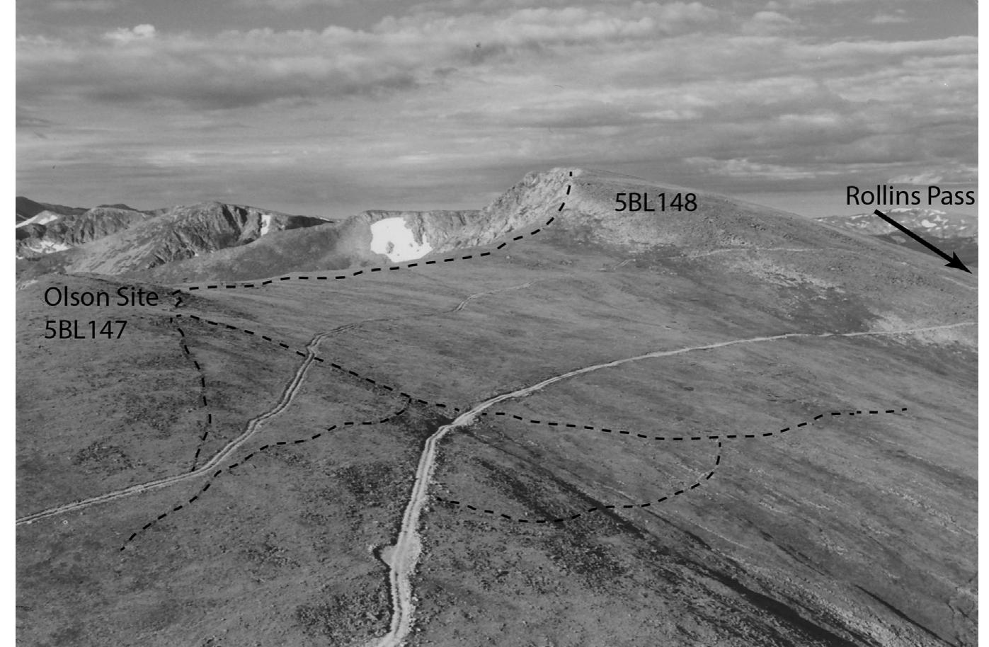 Fig. 3. Aerial overview of the major drive walls (dashed lines) of the Olson site (5BL147) in relation to an adjacent game drive (5BL148; walls not depicted). View is looking west/ southwest, with Rollins Pass located in the saddle along the right side of the figure. Two pathways of the 1860s—1870s wagon road constructed by John Q.A. Rollins cross the site from east (left) to west (right). Photo from the John Slay archives, Center for Mountain and Plains Archaeology, Colorado State University. 