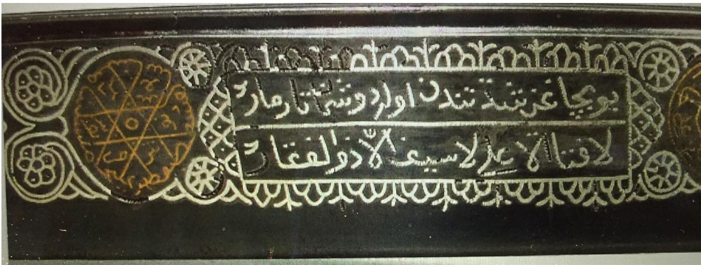 Fig, 17. Ottoman seal bearing the names of the Companions of the Cave; the inverted letters of the name of Qitmi occupy the centre. Collection of Halak Perk, Osmanh Tilsim Mihiirleri. Halak Perk Koleksiyonu, 95.  Fig, 18. A detail of the blade of a sword with an engraving of the names of the Companions of the Cave in the form of a hexagon. http://yataghan3.blogspot.com accessed May 2021.   the Seven Sleepers and their dog Qitmir are also written in circular fash- ion to form a hexagon or Solomon’s seal.” This hexagonal figure may be found in numerous inscriptions and artefacts, even non-religious ones: for instance, as noted by Seligman, it appears in talismans made by the impression of the seal of the Shaykh of the Mosque of the Rock in Jeru- salem,”’ on the top of a religious skullcap, in a band around the edge of 1 mirror, etc.’ On can find also the hexagon engraved on an Ottoman sword (yataghan) dated 1900-01 to protect the soldier who carried it. Such 1 practice is directly connected with the spirit of the Futuwwah, since the soldier might be also engaged in an inner battle against his ego. This spiritual dimension can be confirmed by the fact that the yataghan bears also, near the hexagon of the Companions, the well-known Shri formula La fata ila ‘Ali, la Sayfa ila Dhul'figar (“There is no youth like ‘Ali and no swotd like Dhul'fiqar’’), which hints at the fabulous sword of the valorous Ali, son-in-law of the prophet Muhammad (Fig, 18).°? We do know an  D. B. Macdonald, “Description of a silver amulet,” Zeitschrift fiir Assyriologie und Vorderasiatische Archaologie vol. 26:1-3 (1911), 267 (267-69). 
