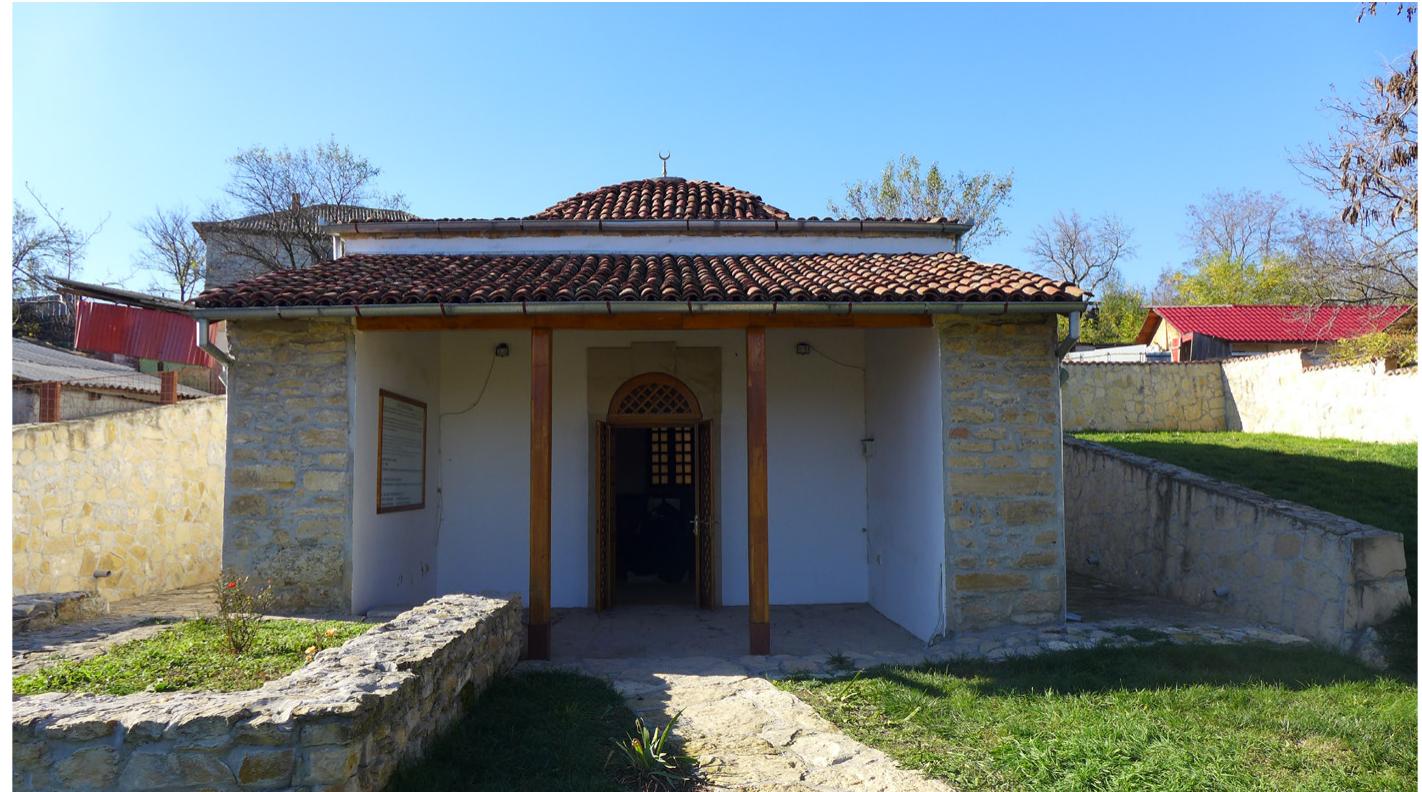 Today there is no trace of Sari Saltuk’s zaviye at Babadag, south of ‘Tulcea, in the Romanian Dobrogea (Dobruja). The holy man’s #irbe was last renovated and re-inaugurated by the Turkish Prime Minister Recep Tayyip Erdogan in 2007. The “irbe consists of a domed tomb chamber and a portico that is open to the front, supported by two wooden posts and covered by a roof. Photograph © Sara Kuehn.  town’s central place of veneration was Saltuk’s tomb (éirbe). However, a  probably as a result of Mehmed II’s harsh measures against the no formist dervish communities in the Balkans, denounced for their  in Babadag in 1484-5 the “irbe and zaviye were substantially rebuilt.  few decades later, according to Evliya Celebi, the holy man’s commemora- tive structure was destroyed and covered with earth, stones, and garbage,  ncon- ‘inno-  vations’ in practice and beliefs. Unlike Mehmed IJ, his son and successor, Bayezid II (r. 1481-1512), was a patron of Sufi lodges and during his visit  It was  in the vicinity of this holy site that in 1473 Bayezid II’s younger brother, Prince Cem (d. 1495), heard stories about Sart Saltuk from the saint’s  Ebu’l-  followers. He subsequently asked a member of his court, a certain |  Khayr Rumi, to collect the extraordinary oral and built traditions circulat- ing about the holy figure in the hagiographic compendium Saltukname, ot  Book of Saltuk (gathered by c. 1480).*°  Machiel Kiel, “The Tiirbe of Sari Saltik at Babadag-Dobrudja. Brief Historical and Architec-  tural Notes,” Giiney-Dogu Avrupa Arastrmalant Dergisi 6 (1977-78): 205-25. 