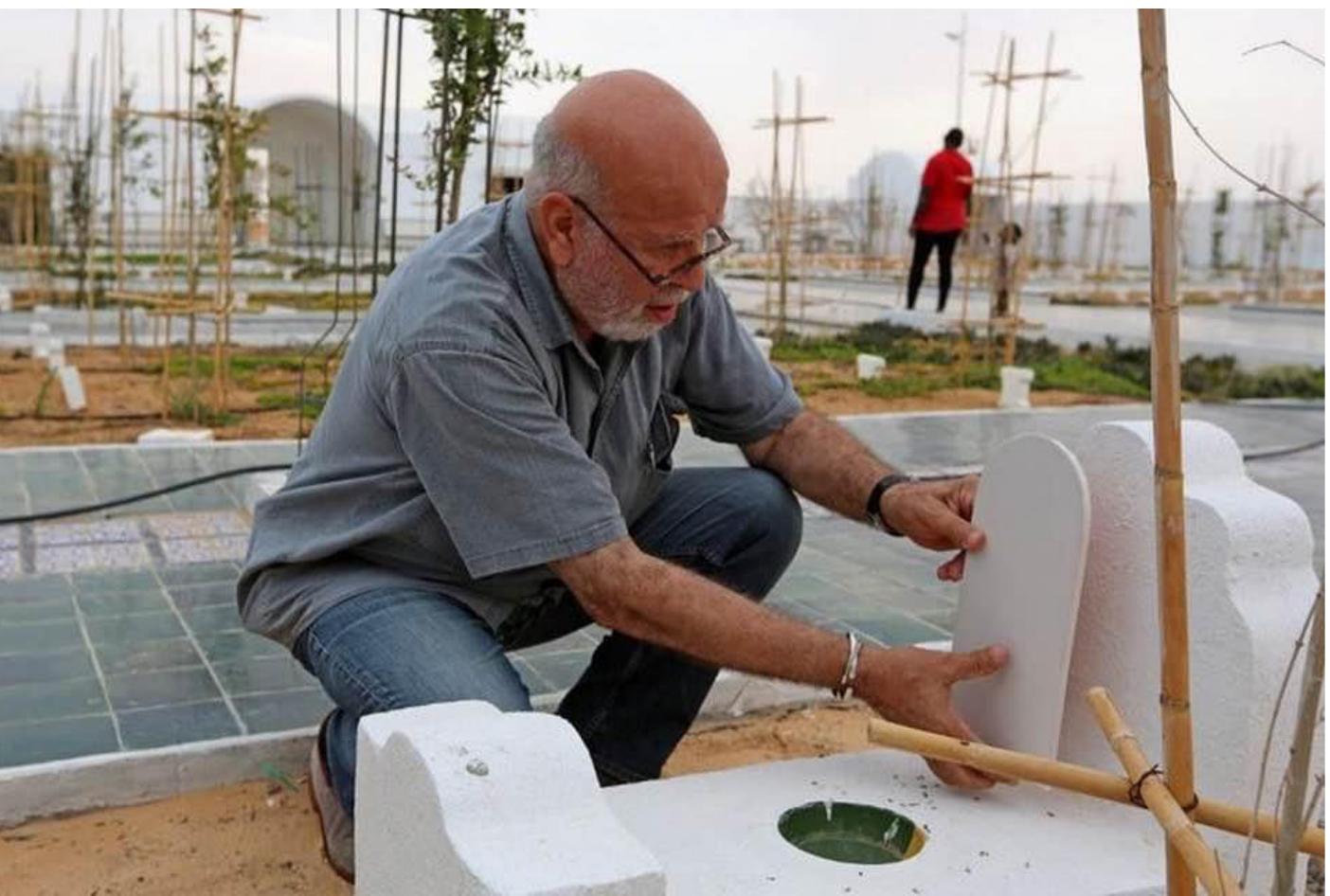 Fig, 3. Koraichi attaches a plaque to a tombstone; the yellow-green bow! on the grave is meant to catch rainwater and attract birds, Le Jardin d’Afrique, Zarzis, Tunisia. Photograph © Rachid Koraichi. 