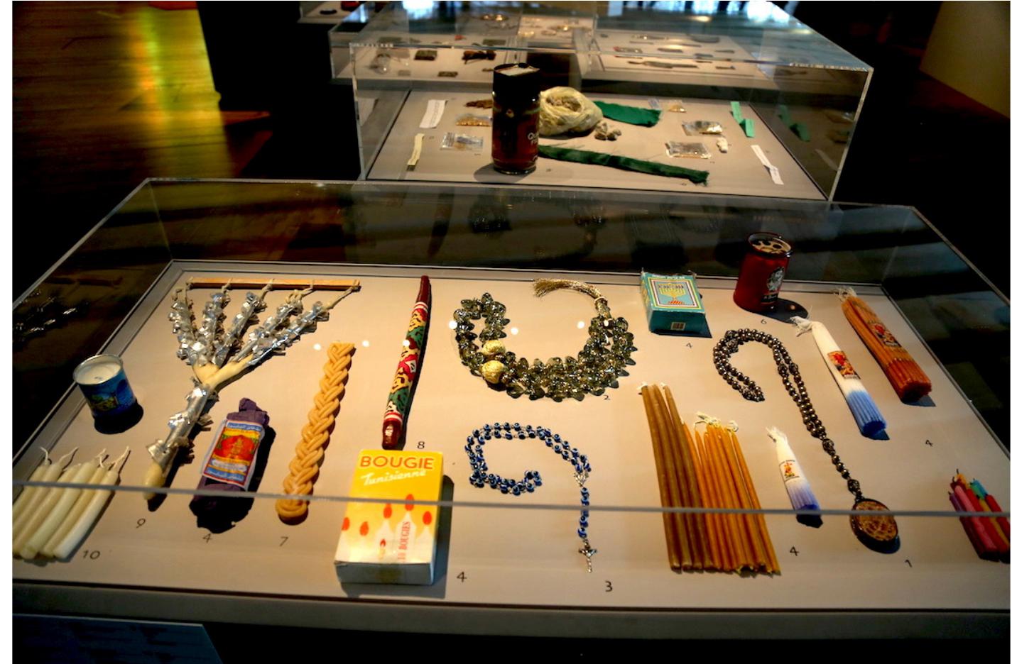 Fig. 14. Display case with popular devotional objects, Liewx saints partagés, Mucem, 2015. Photograph © Manoél Pénicaud.  defined as “enquétes-collectes”: ethnologists carried out short fieldwork studies and brought back objects linked to a specific social practice.'” This practice has been inherited by the Mucem. Therefore, in the years before our exhibition, we had the possibility to travel to Morocco, Turkey, Tunisia, Israel-Palestine, Italy and the Republic of North Macedonia, bringing back ethnographic materiality: artefacts, ex-voto, candles, rosaries, etc. (Fig. 14). We also collected sound and visual elements to use them in space-design- ing processes and/or ethnographic films displayed for visitors (Fig, 15).  This practice of these “enquétes-collectes” was inaugurated by Georges-Hentri Riviere. See Germain Viatte G. and Marie-Charlotte Calafat, op. cit.; Collectes sensorielles : Recherche-Musée-Art edited by Véronique Dassié, Aude Fanlo, Marie-Luce Gélard, Cyril Isnart and Florent Molle (Paris: Pétra, 2021).  This writing process can be divided into several distinct phases. ‘The exhibition project is written down on paper, defining the main ideas anc an initial narrative structure. Next, an initial list of works and objects is drawn up to materialise these guiding ideas. This stage requires in-depth research in public or private collections, requests for loans with no guar: antee of results, and the first evaluation of the insurance and transport costs. Thus, the first lists of works are often unrealistically optimist. Only the financial assessment and the availability of the items allow the project to coalesce in a more concrete (and generally more modest) way. 