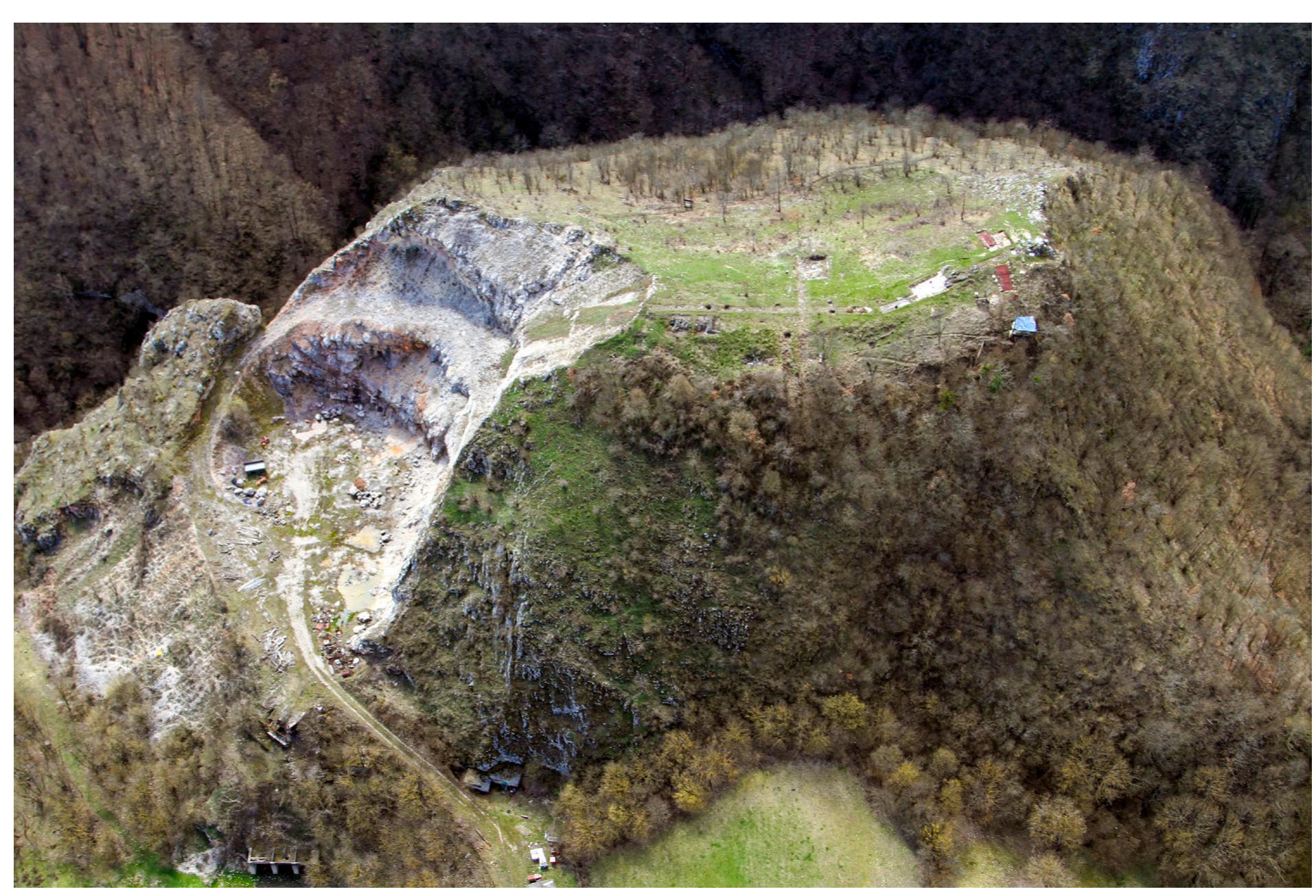 Fig. 2. Dealul Cetatuie de la Ardeu, vedere asupra versantului estic. Se observa suprafata exploatata pentru extragerea arocamentelor (foto S. Berecki 2018).  Fig. 2 Cetatuie hill from Ardeu, view of the eastern slope. You can see the surface exploited for stone extraction (photo S. Berecki 2018). 